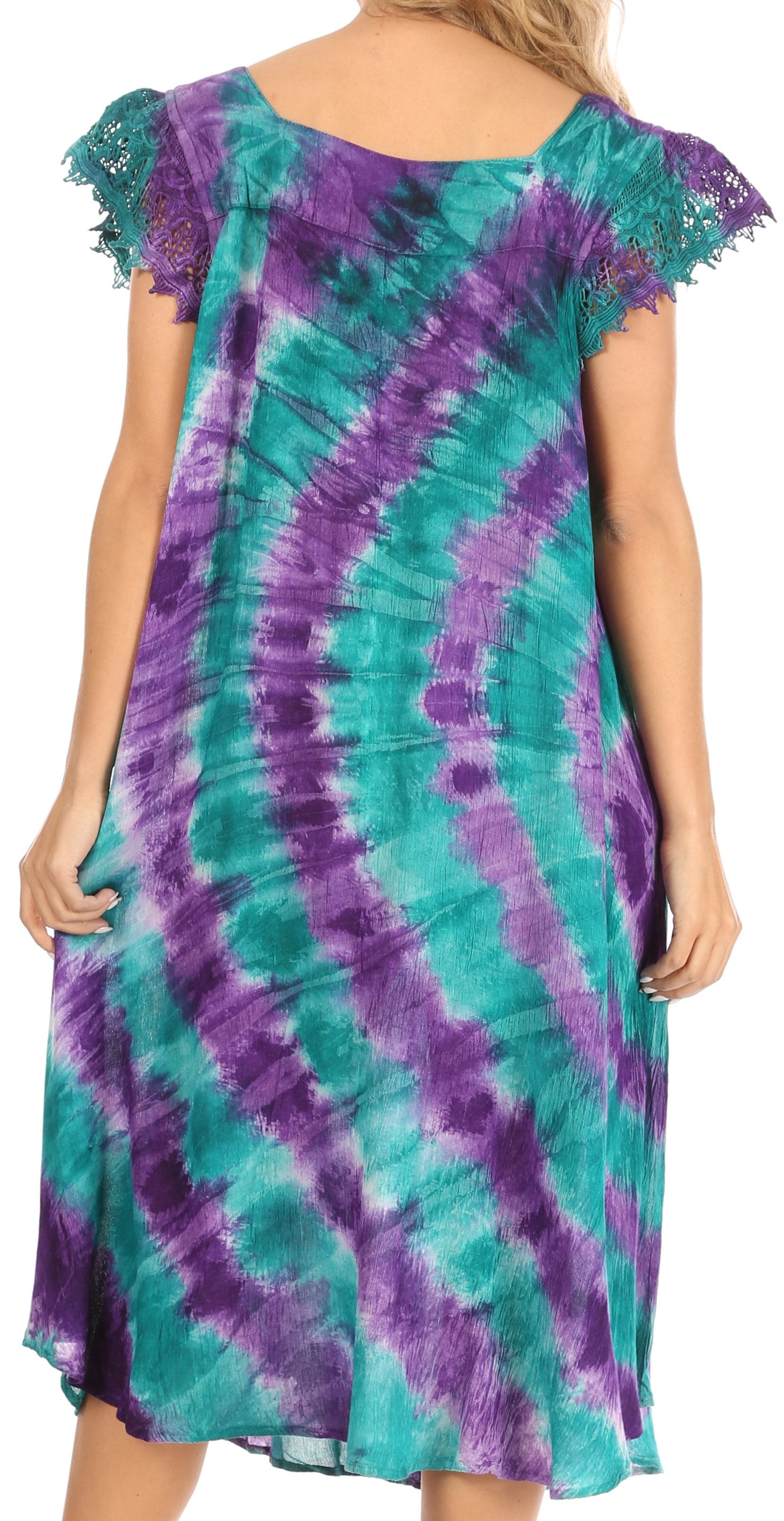 Woman wearing a tie-dye dress with purple and green patterns.
