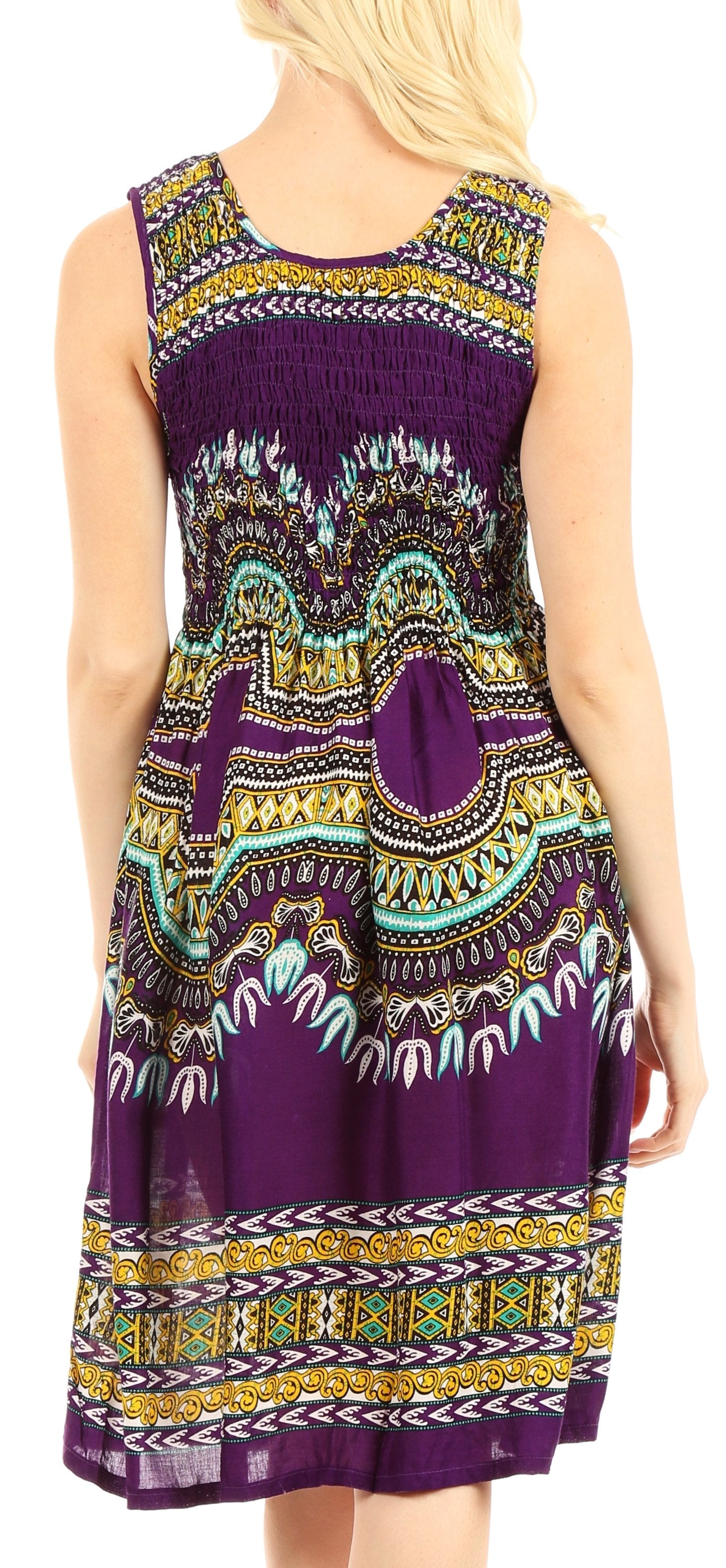 Woman wearing a sleeveless dress with a colorful pattern on a plain background