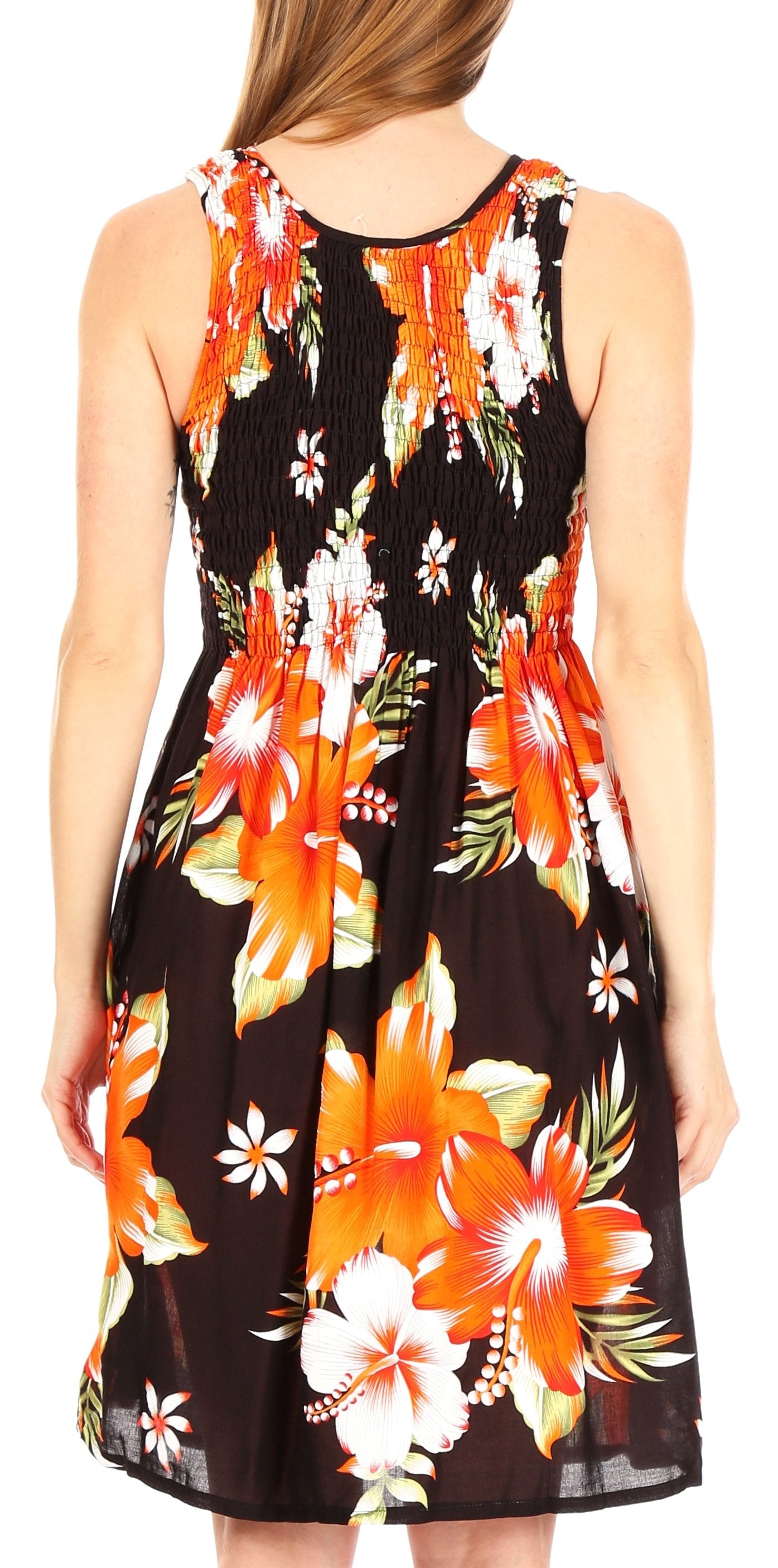 Woman wearing a sleeveless dress with a vibrant floral pattern on a plain background
