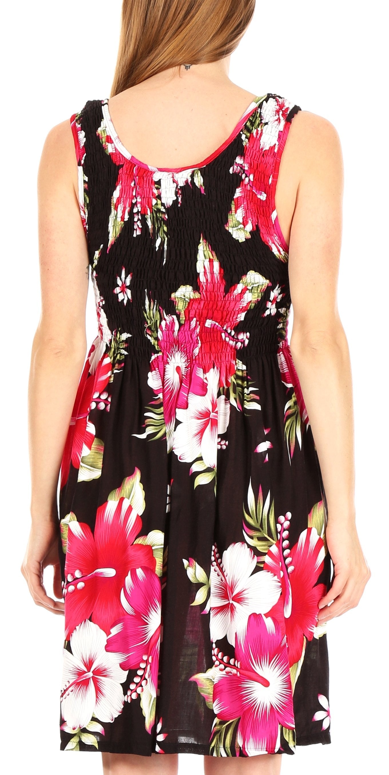 Woman wearing a sleeveless dress with pink floral pattern on a plain background