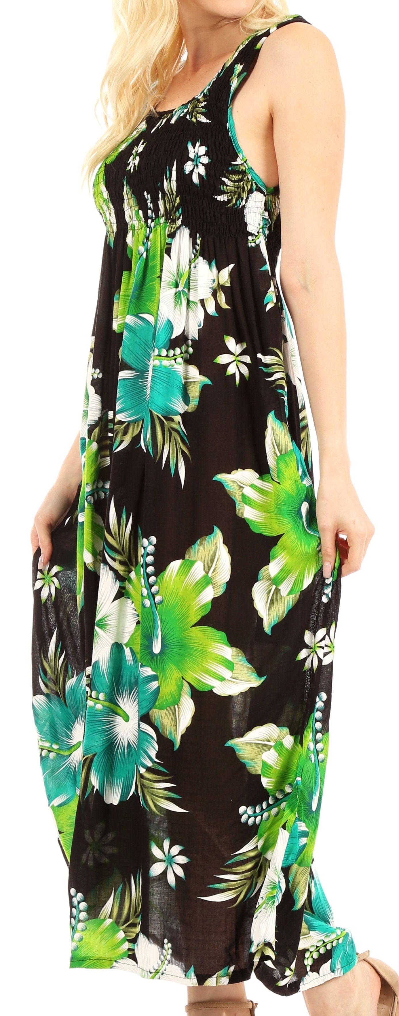 Woman wearing a black floral dress with green and blue flowers on a white background