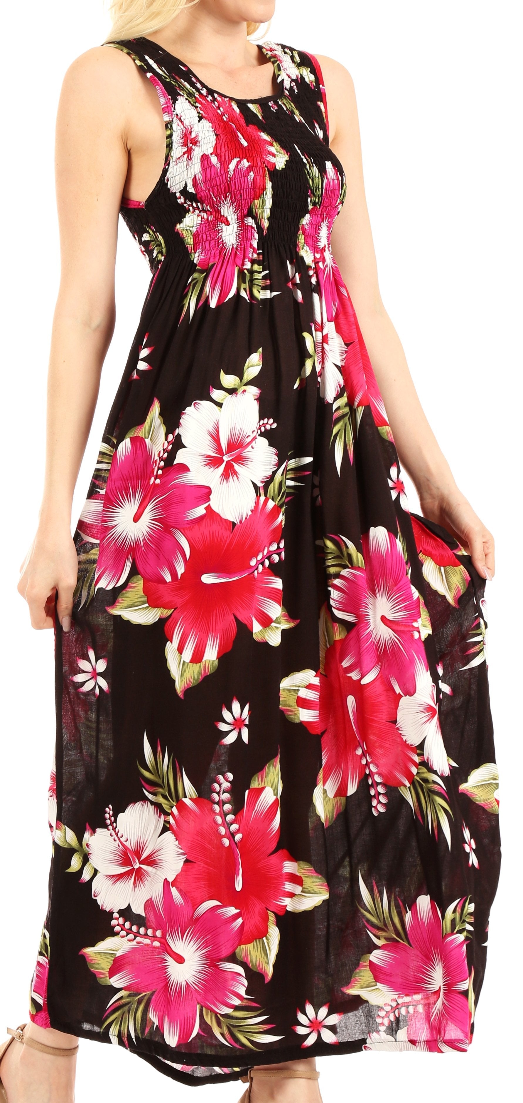 Woman wearing a black floral dress with pink and white flowers on a plain background