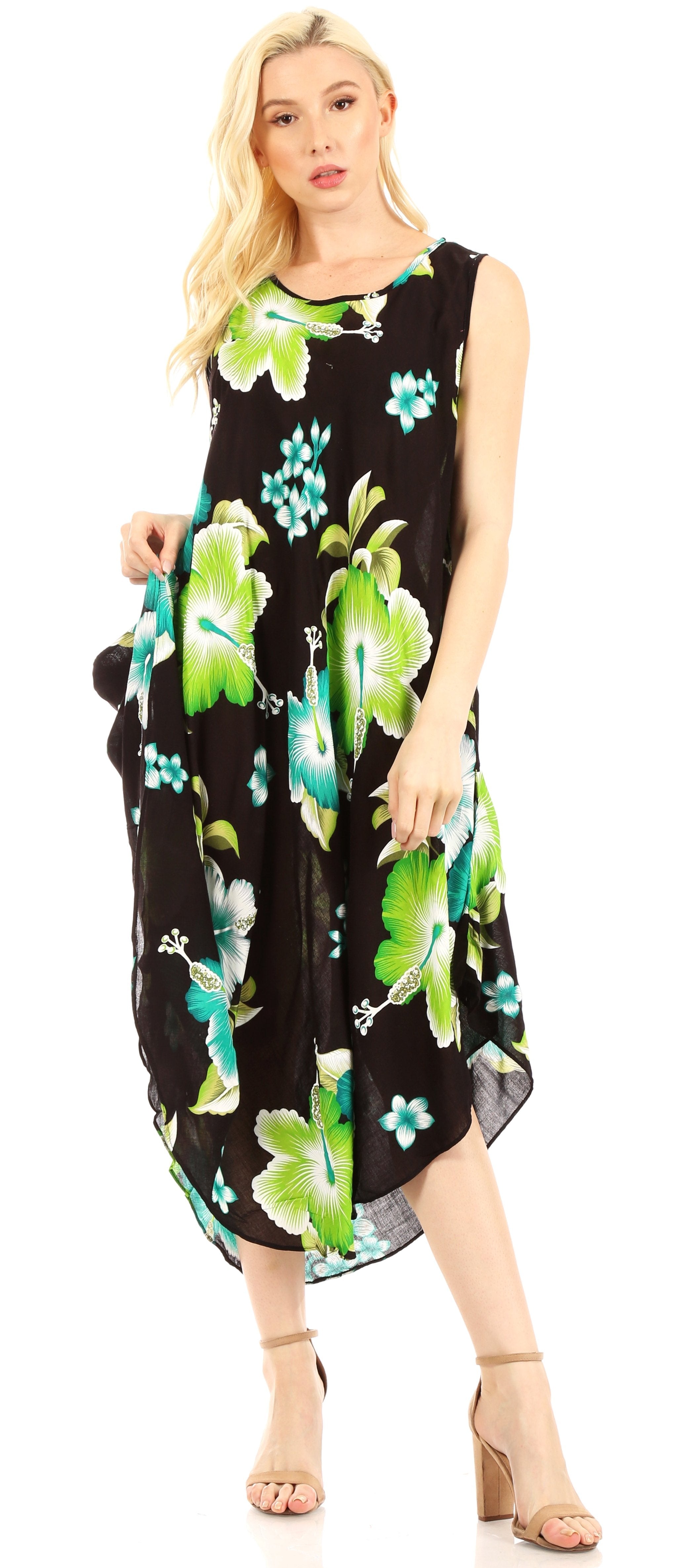 Woman wearing a black sleeveless dress with green floral patterns on a white background
