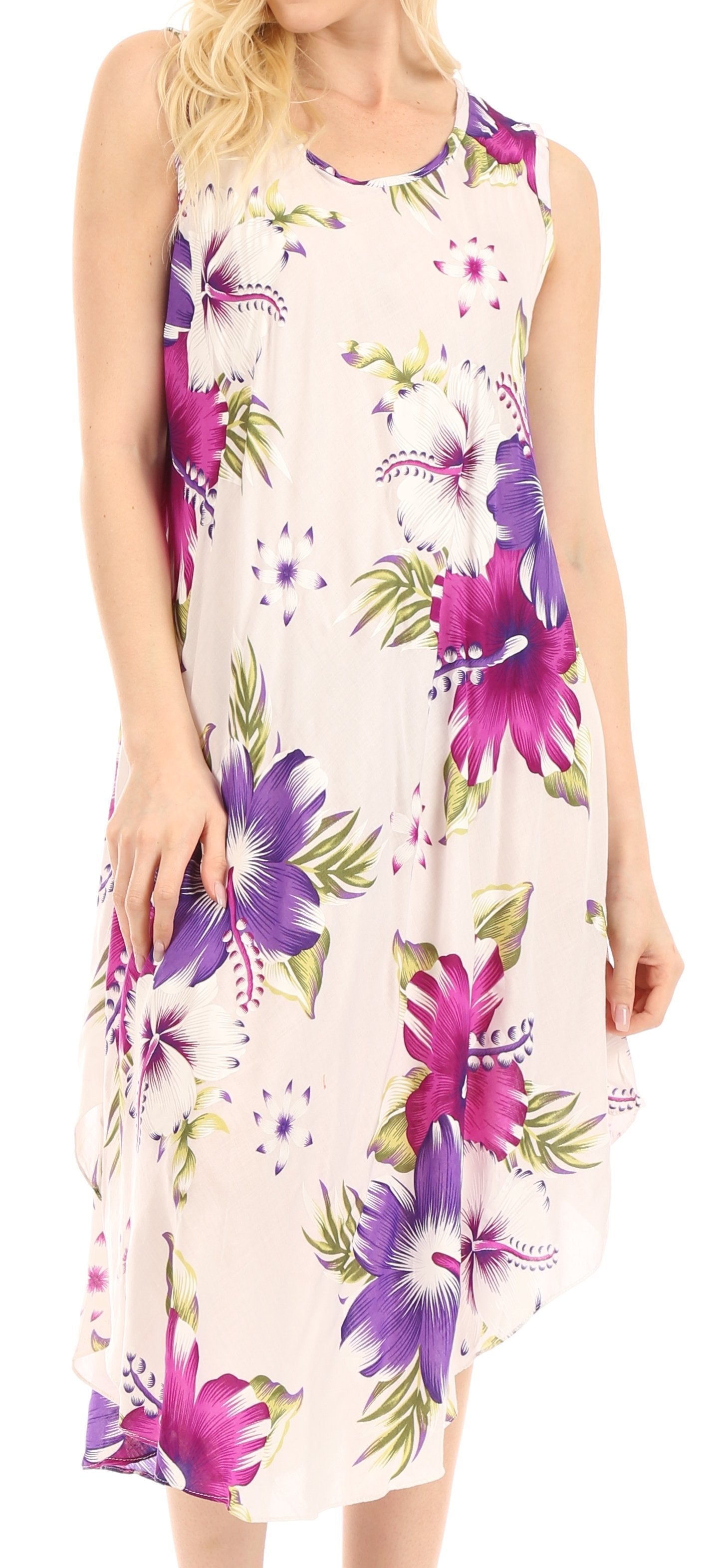Woman wearing a sleeveless floral dress with purple and green flowers on a light background