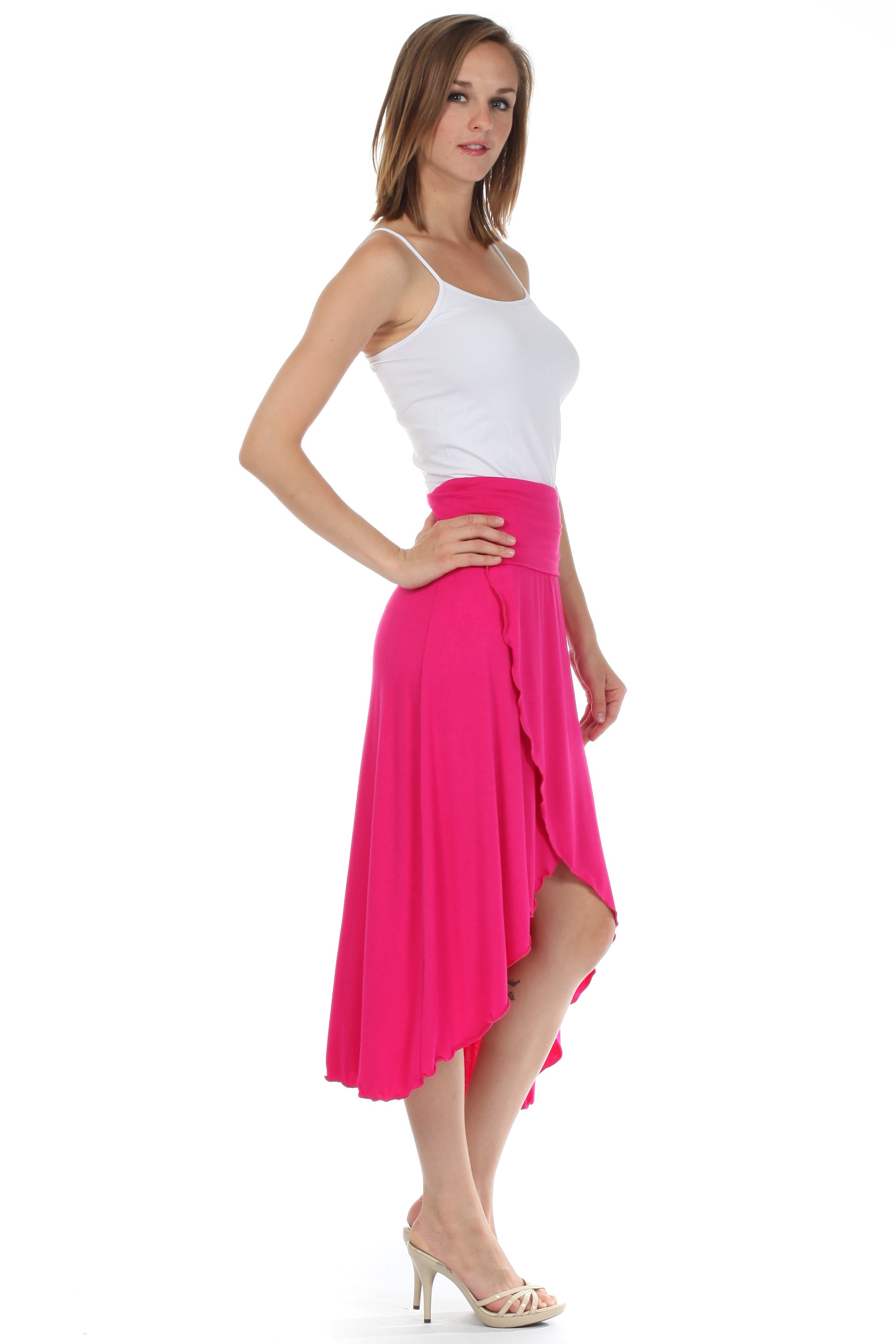 Woman wearing a white top and bright pink skirt on a white background