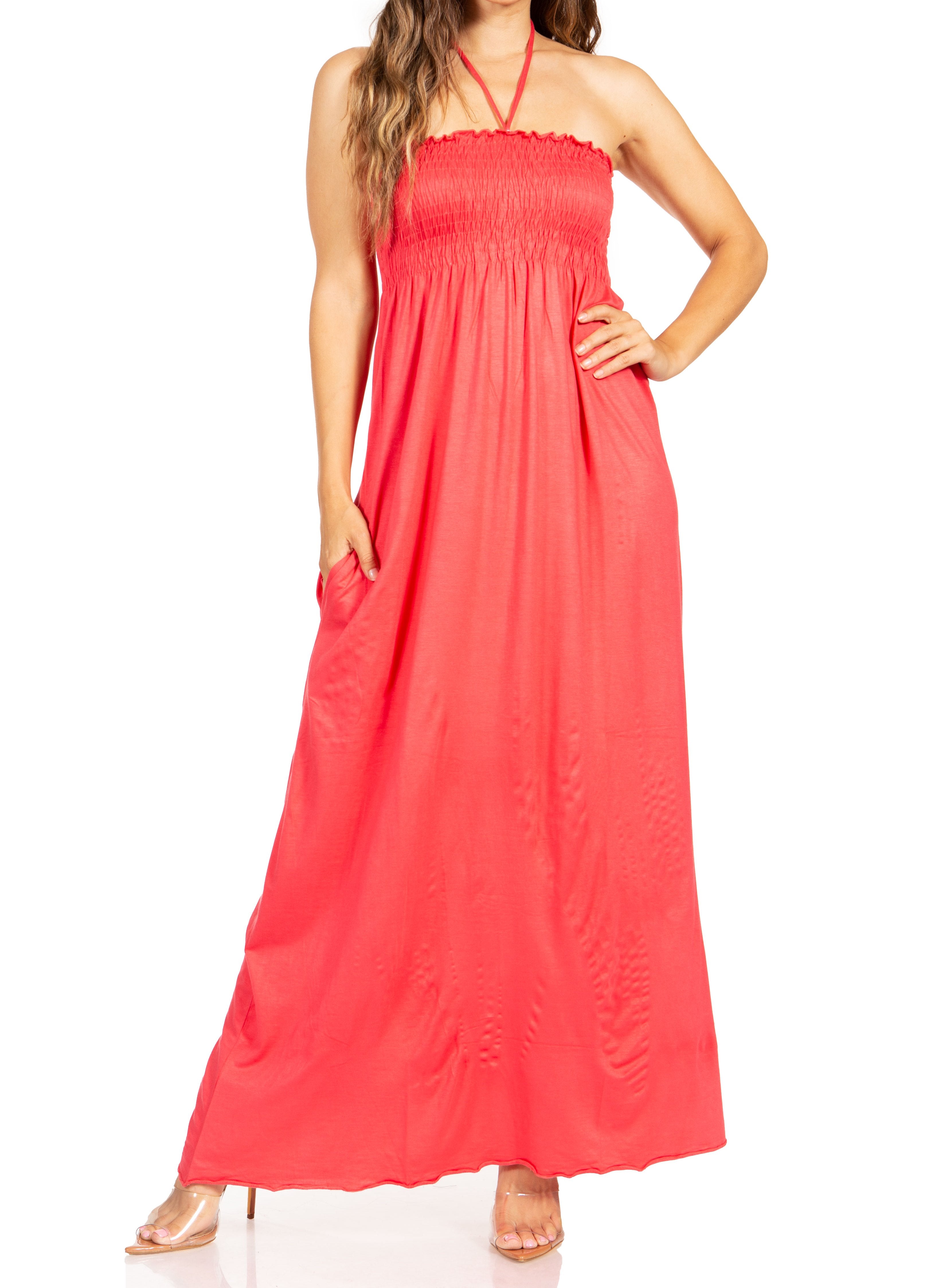 Woman wearing a coral halter neck maxi dress on a white background