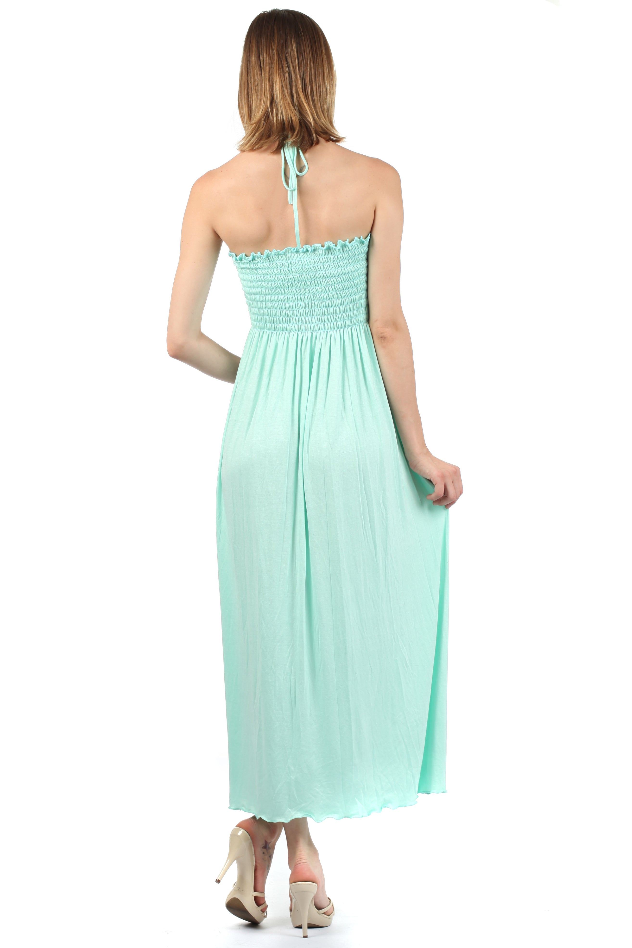 Mint green halter neck dress worn by a model on a white background