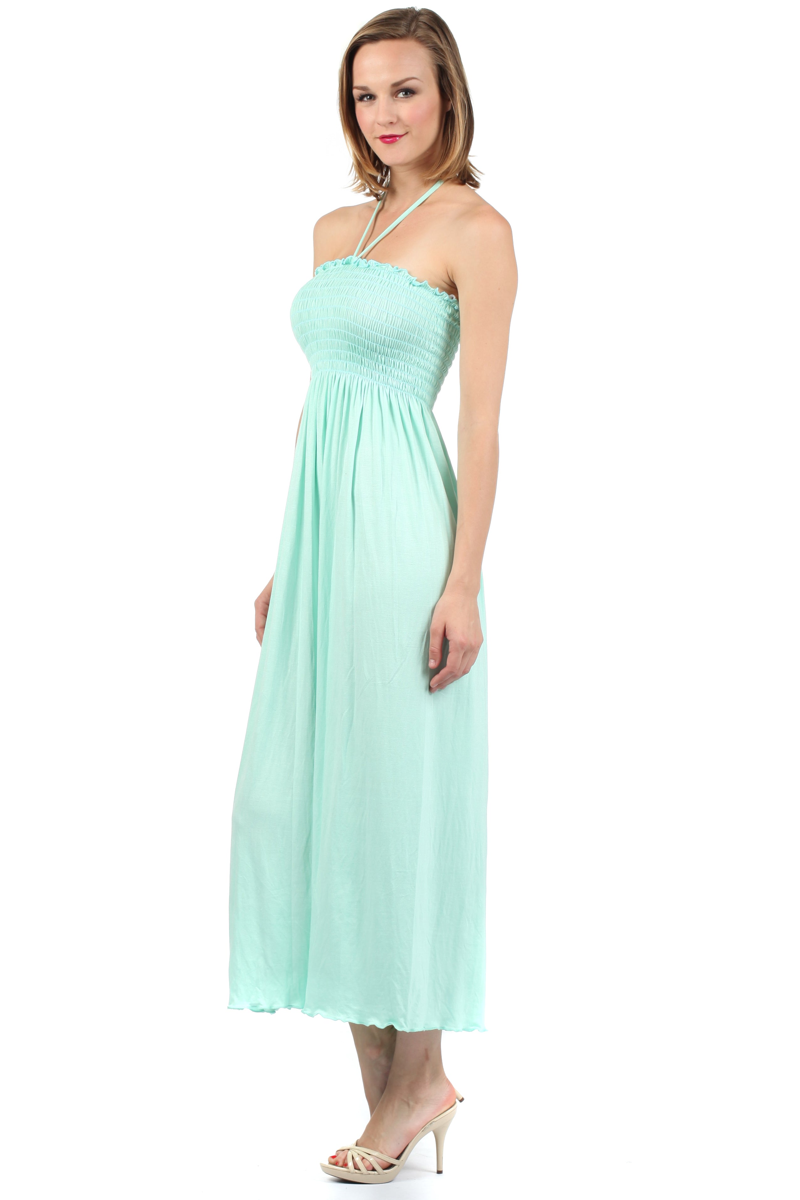 Woman wearing a light blue halter neck dress on a white background