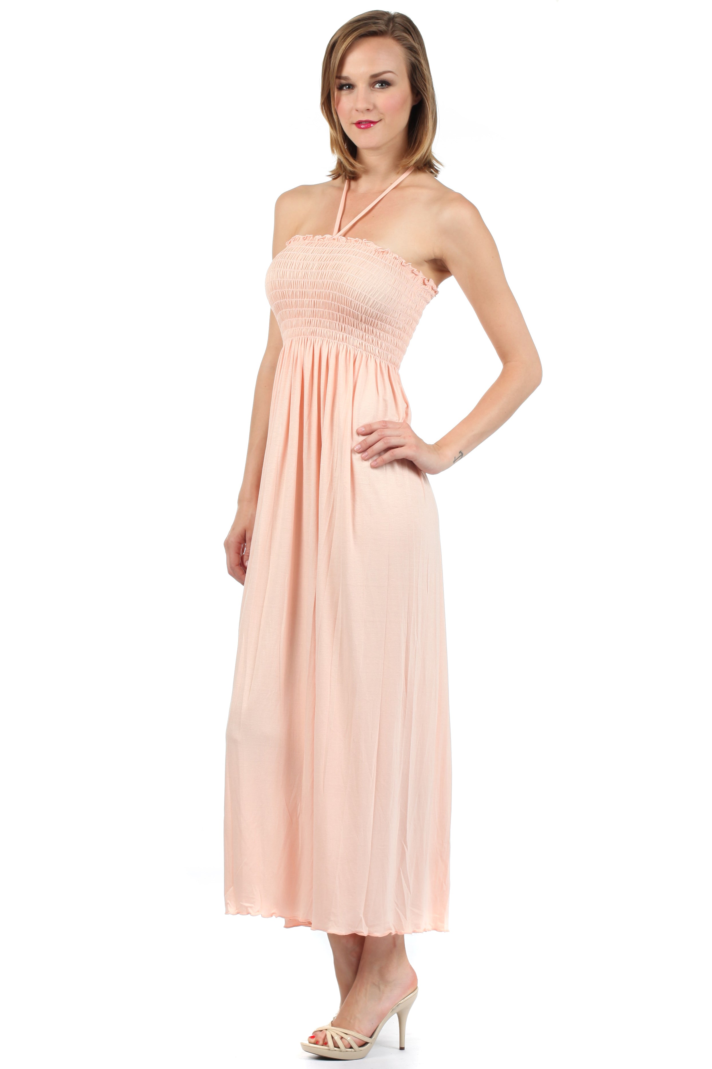 Woman wearing a light pink halter neck dress on a white background