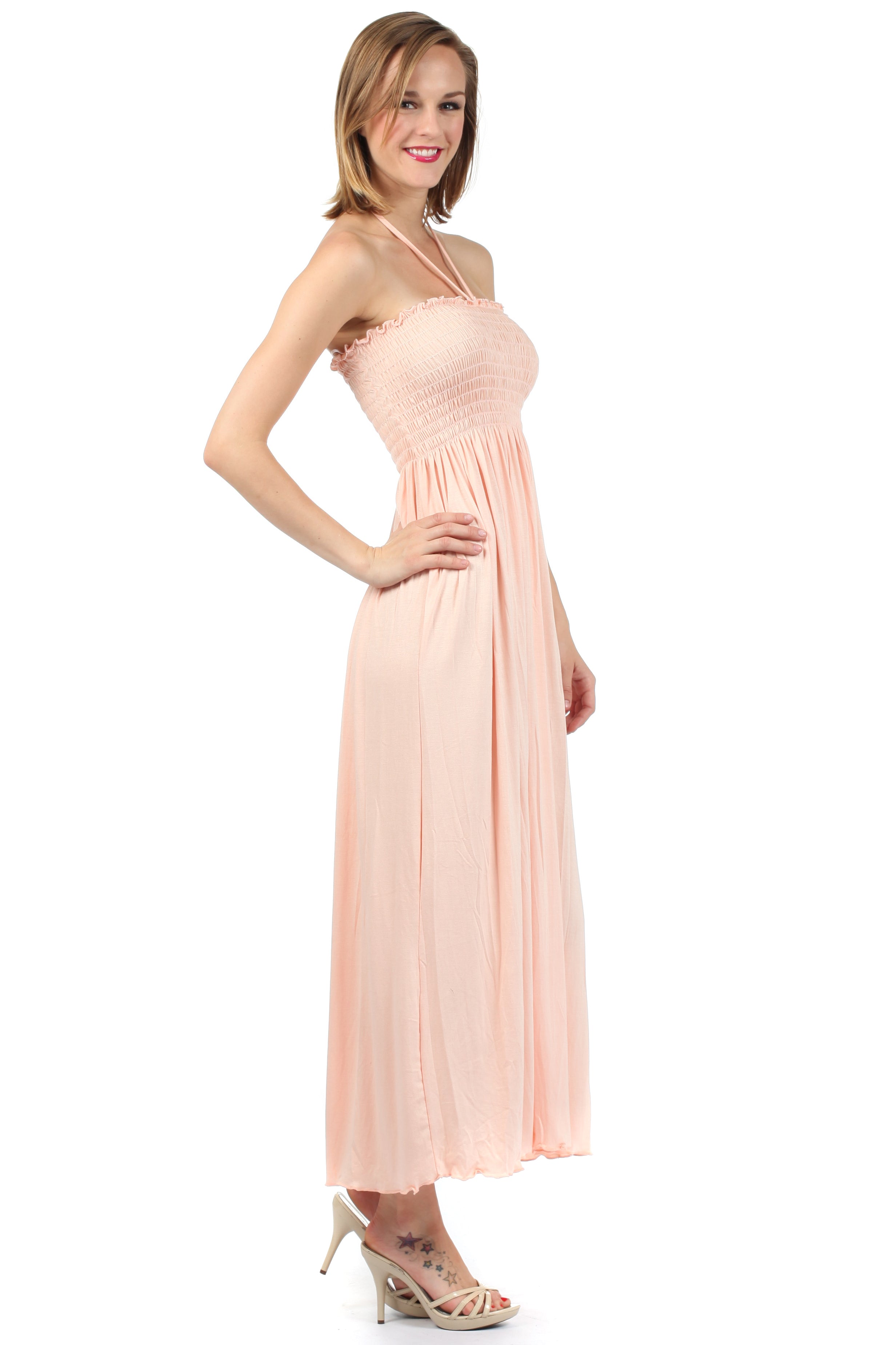Woman wearing a pink halter neck dress on a white background