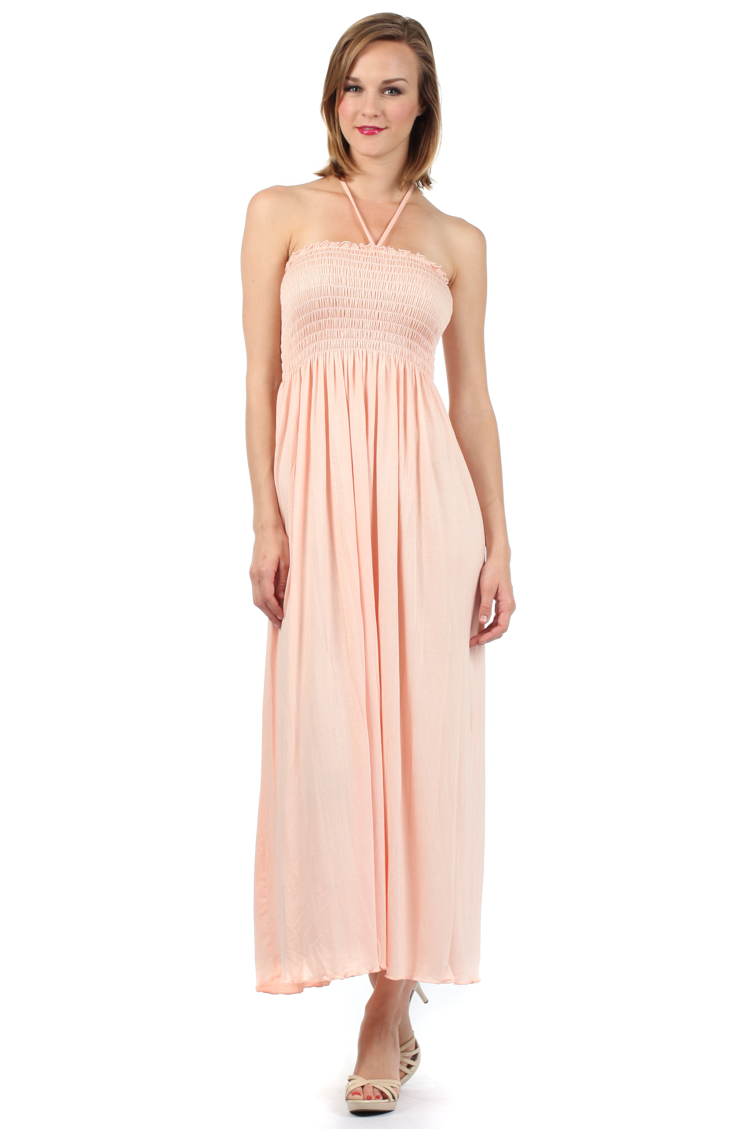 Woman wearing a peach halter neck dress on a white background