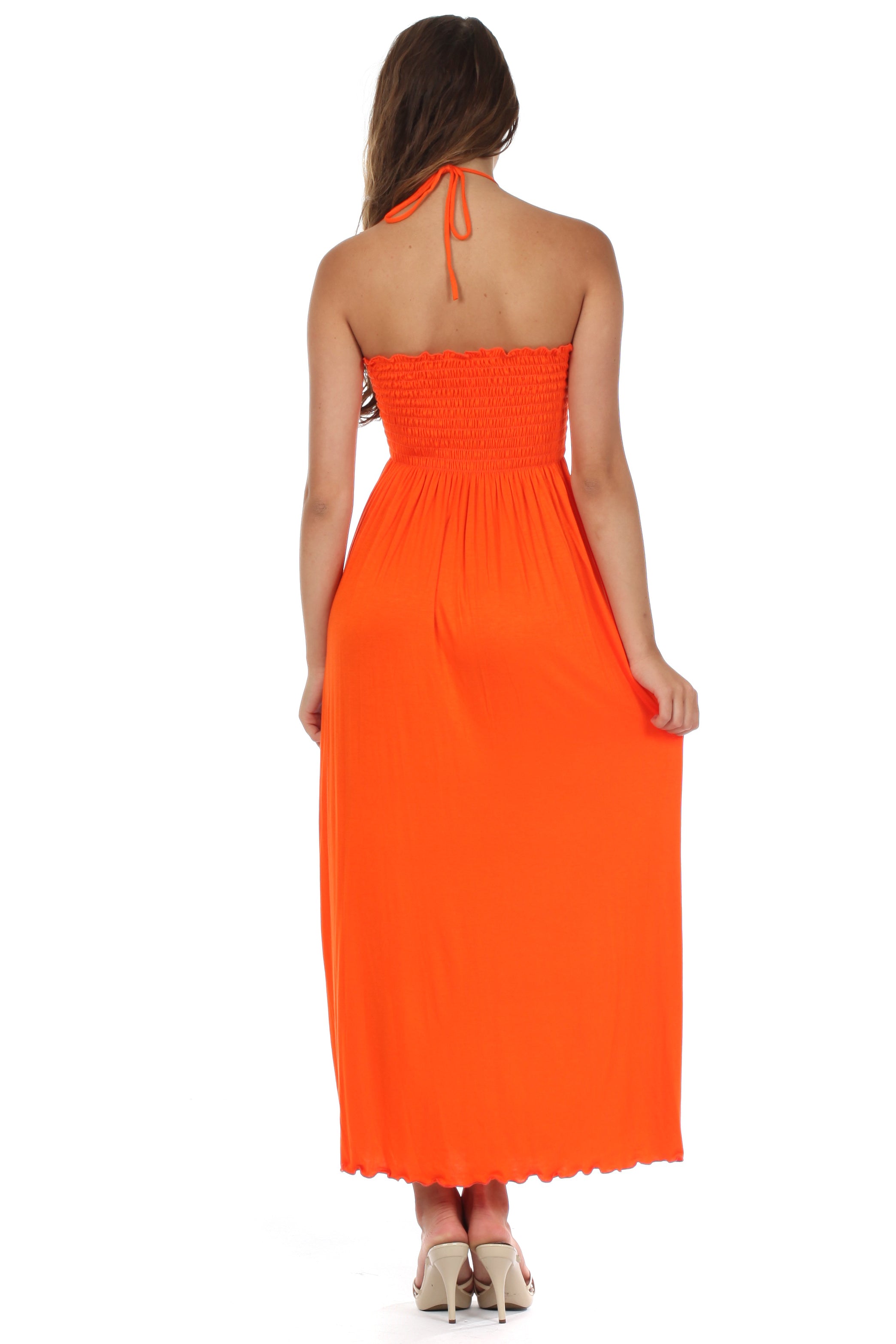 Woman wearing an orange halter neck dress on a white background