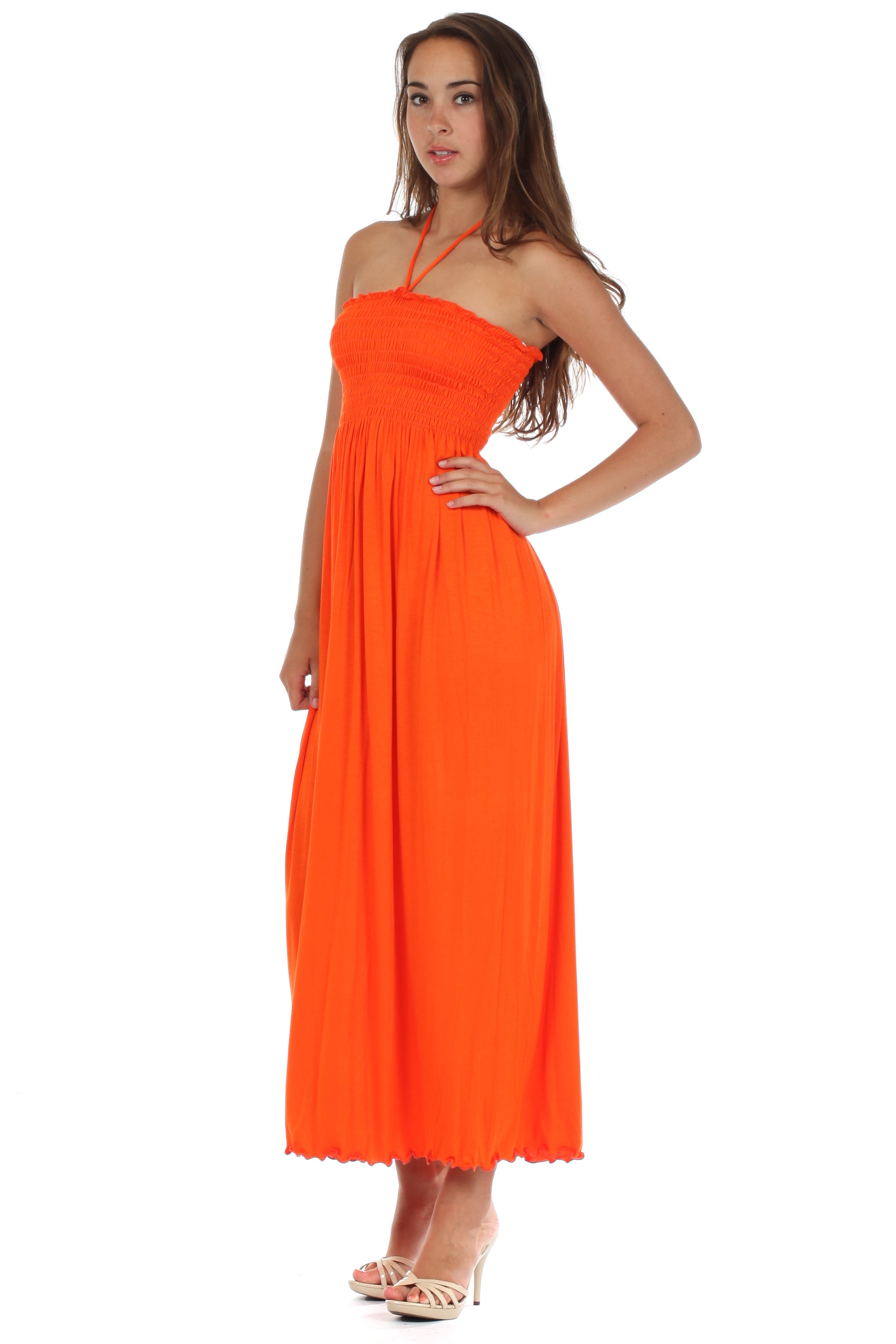 Woman wearing an orange halter neck dress on a white background