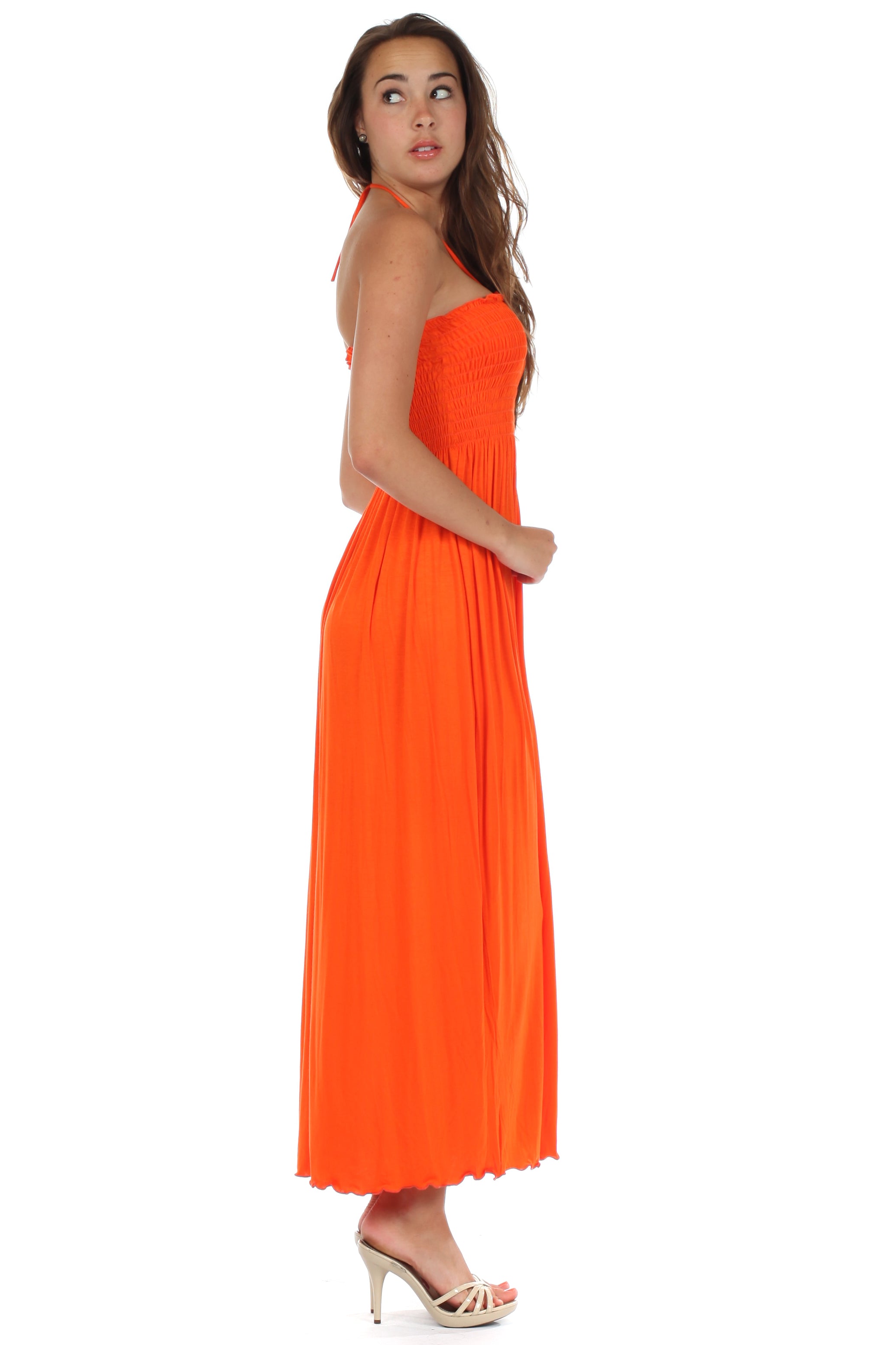 Woman wearing an orange halter neck dress on a white background