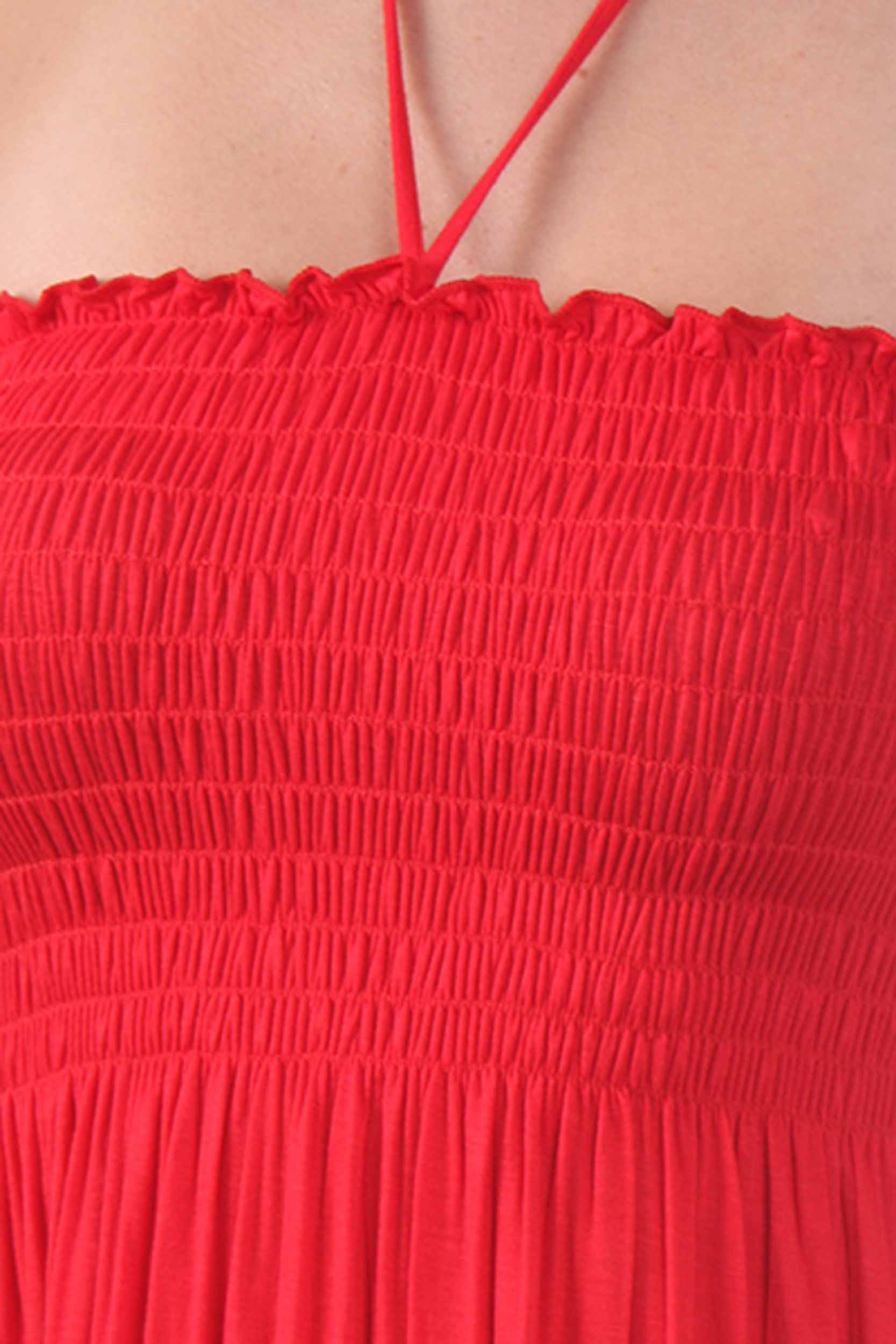 Close-up of a red dress with smocked bodice and thin straps.