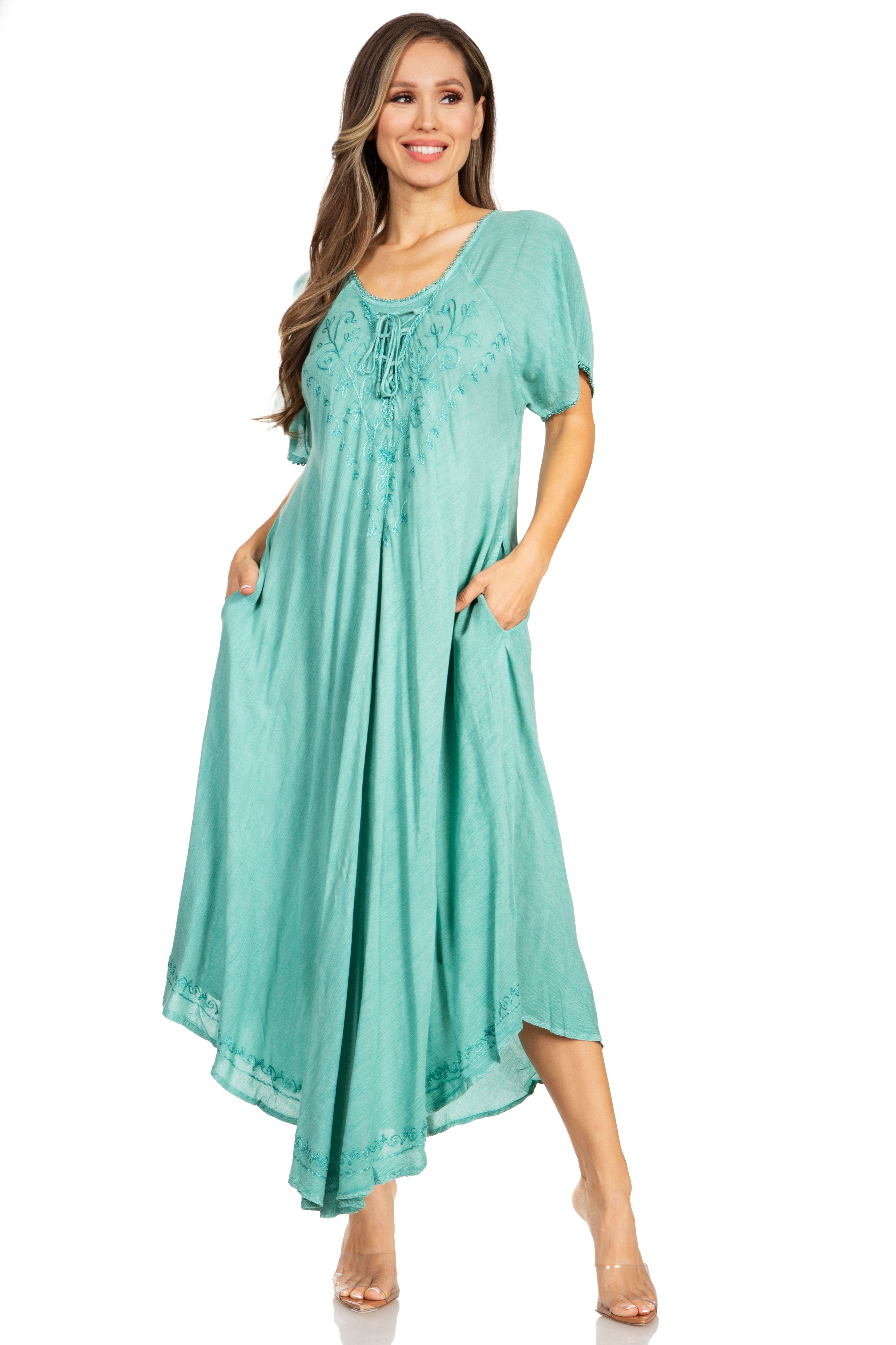 Woman wearing a teal dress with embroidery on a white background