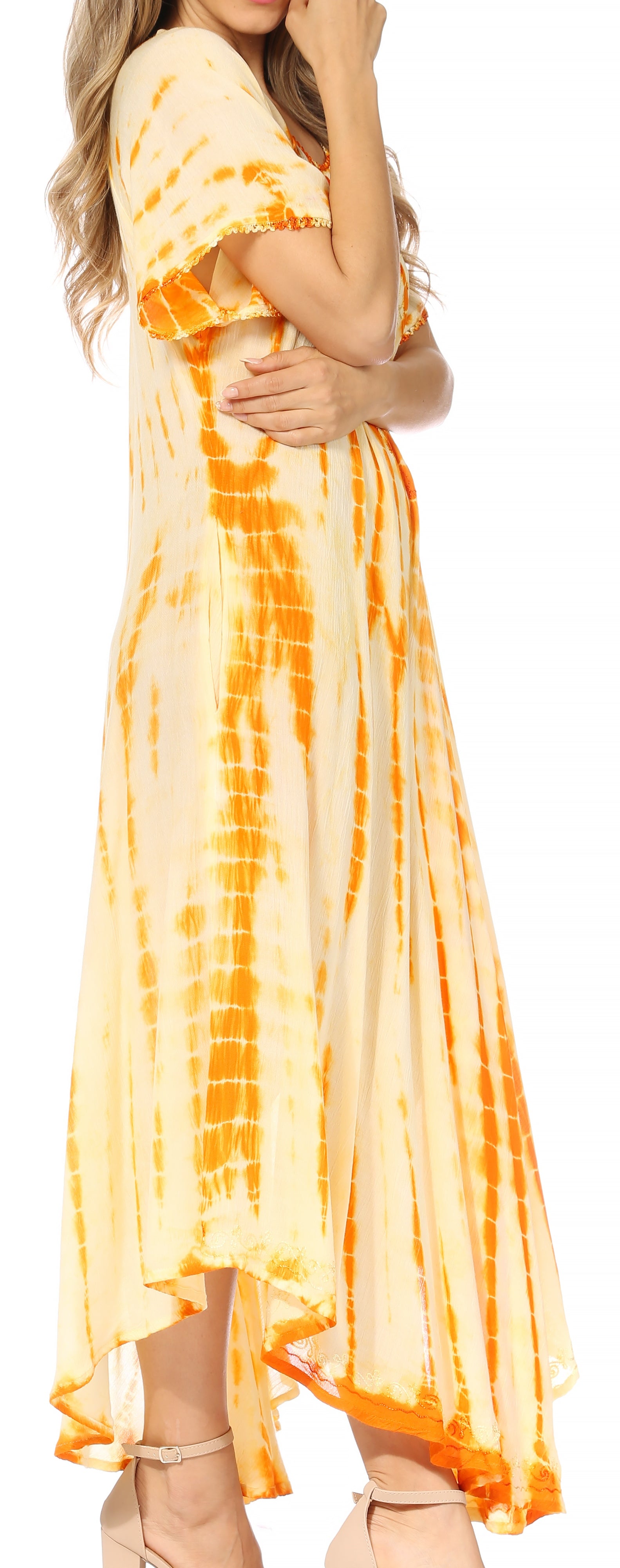 Woman wearing a tie-dye dress with orange and yellow pattern on a white background
