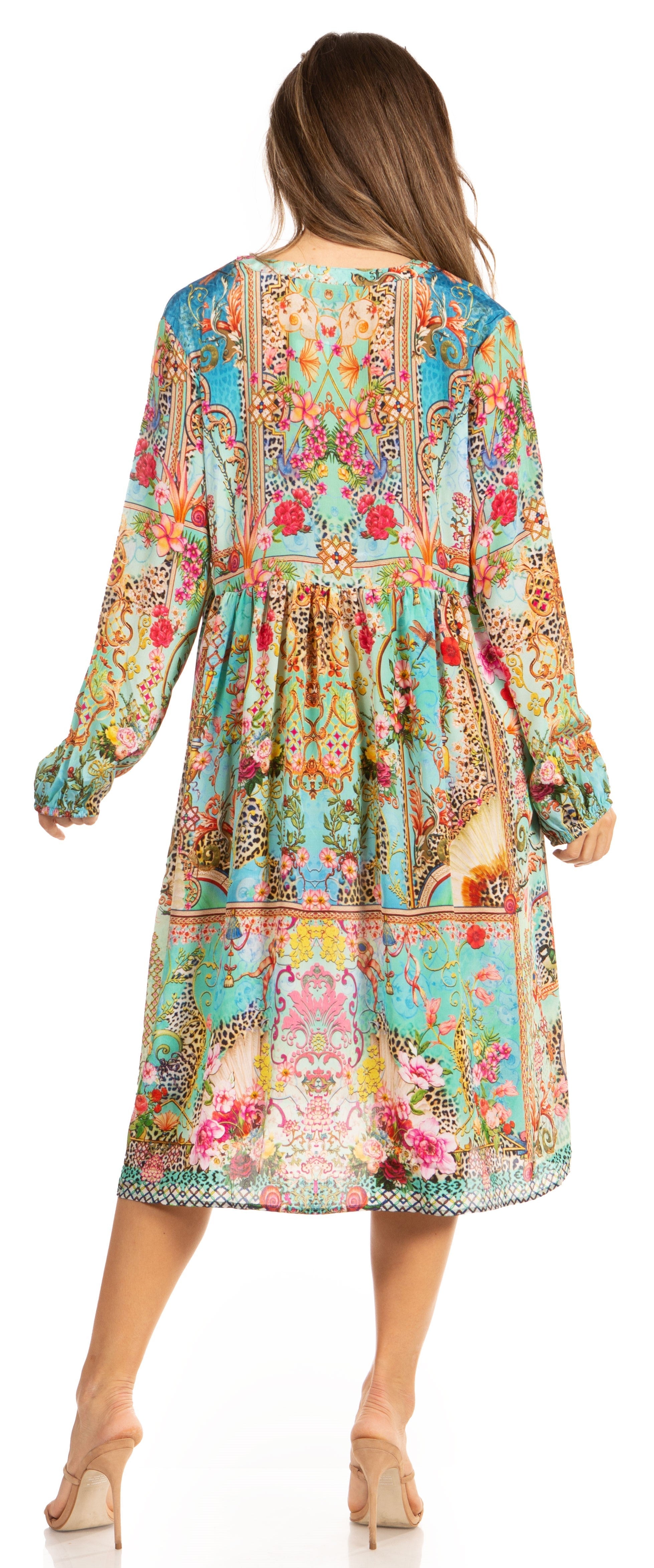 Woman wearing a colorful floral dress with long sleeves on a white background