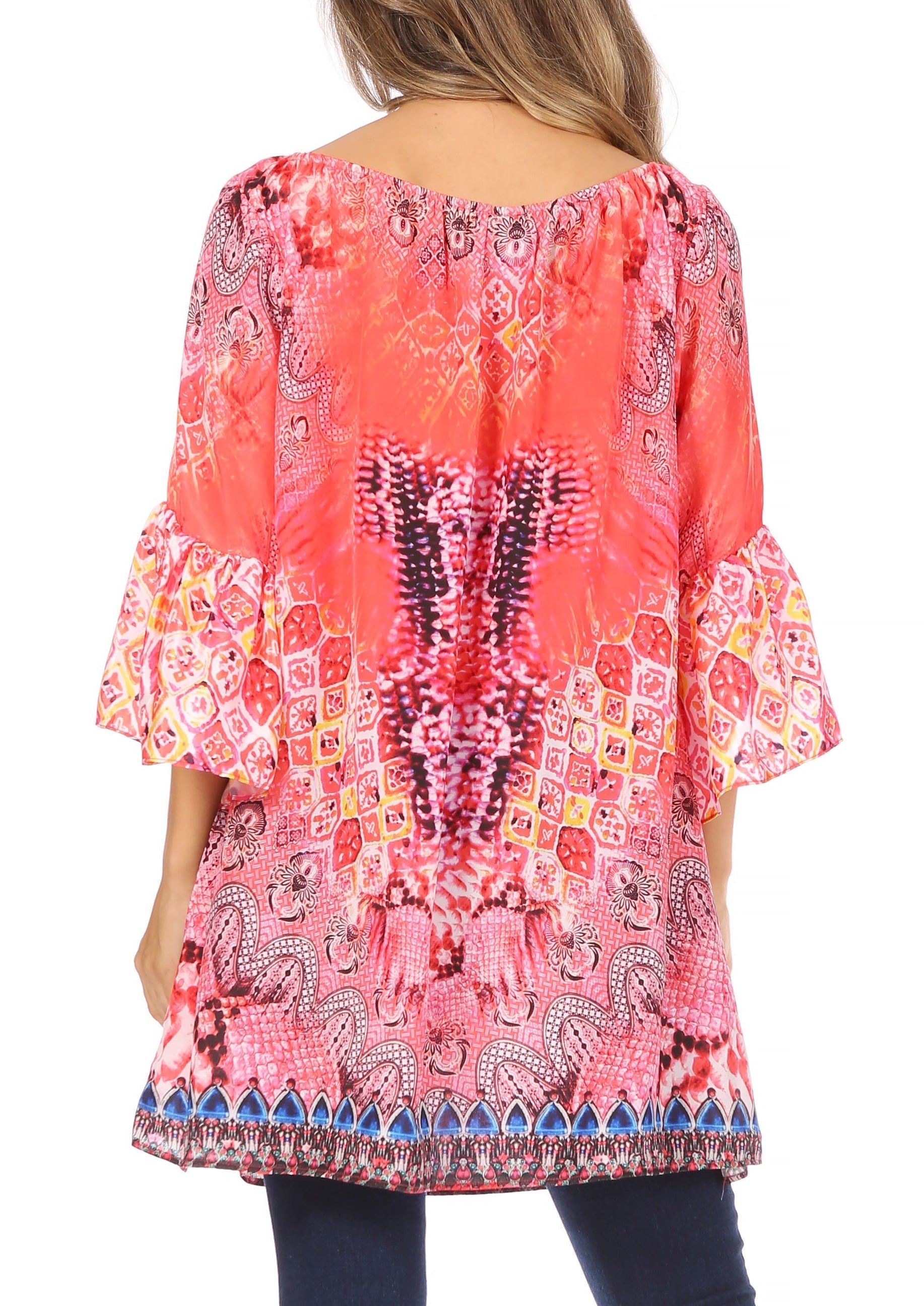 Woman wearing a colorful patterned blouse with bell sleeves on a white background