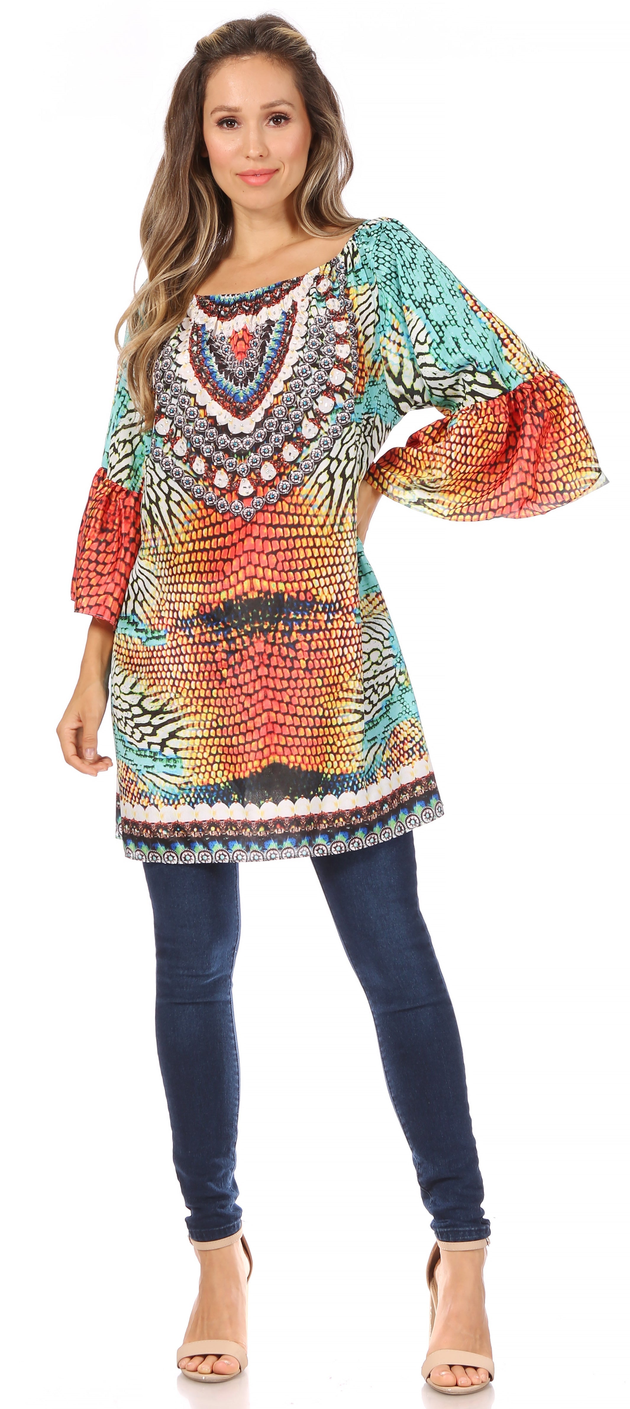 Woman wearing a colorful patterned dress with blue pants on a white background