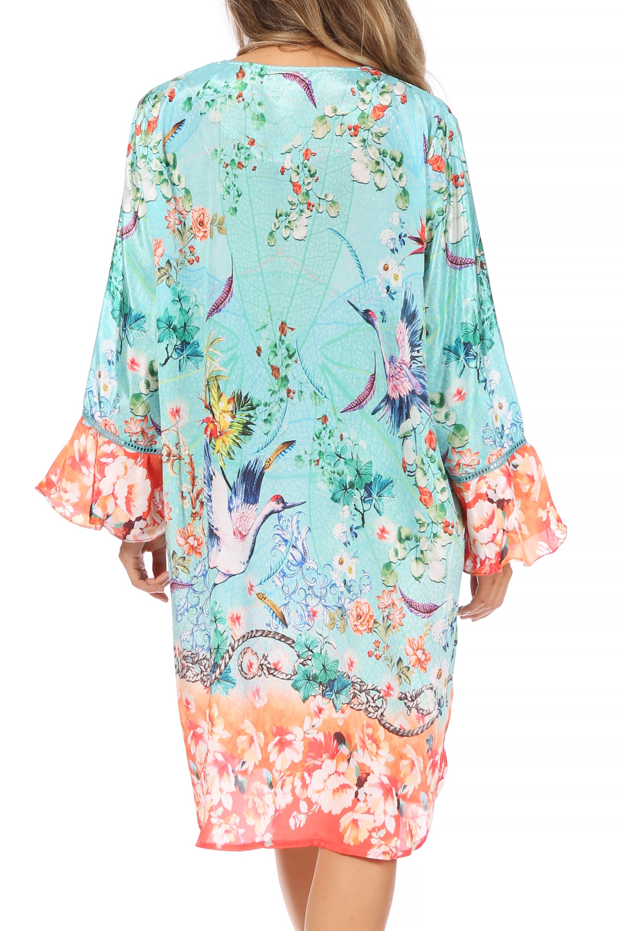 Woman wearing a floral kimono-style dress with colorful patterns on a white background