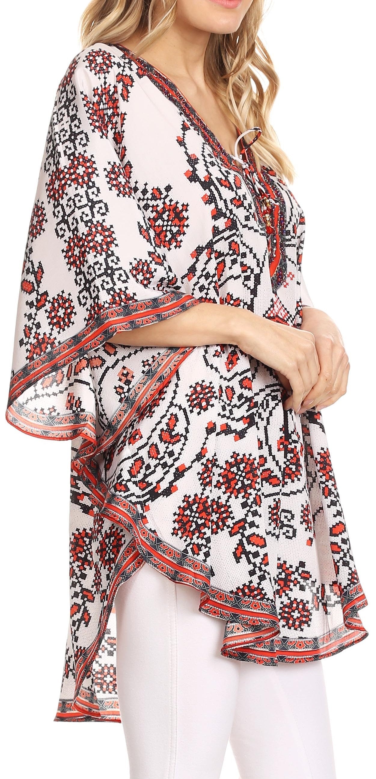 Woman wearing a floral patterned blouse with white pants on a white background