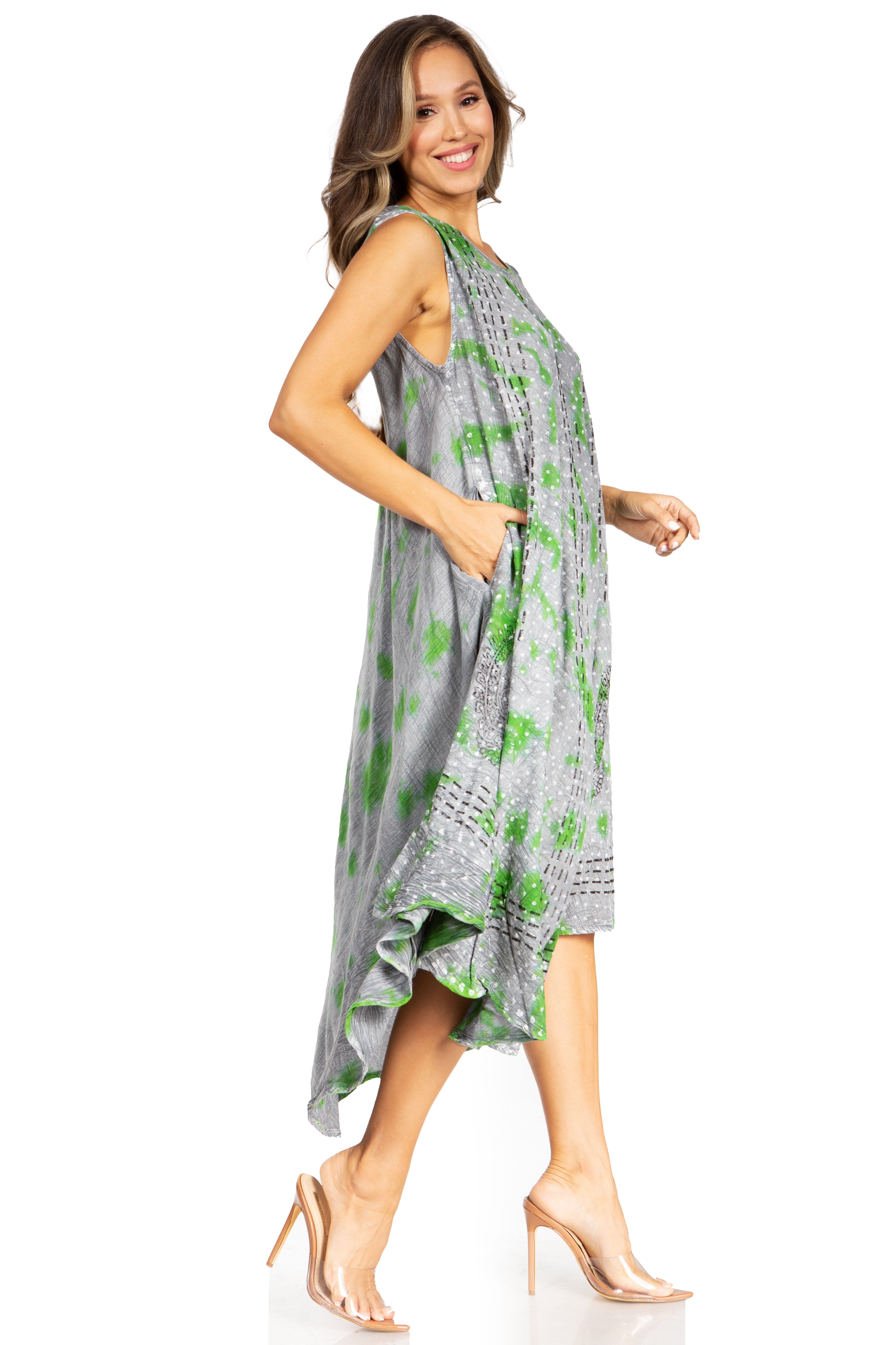 Woman wearing a gray dress with green floral pattern on a white background