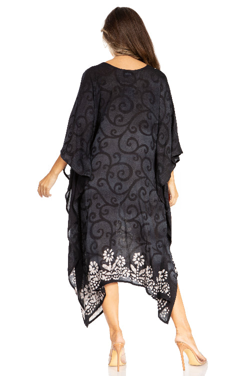 Woman wearing a black patterned dress with white floral embroidery on a white background