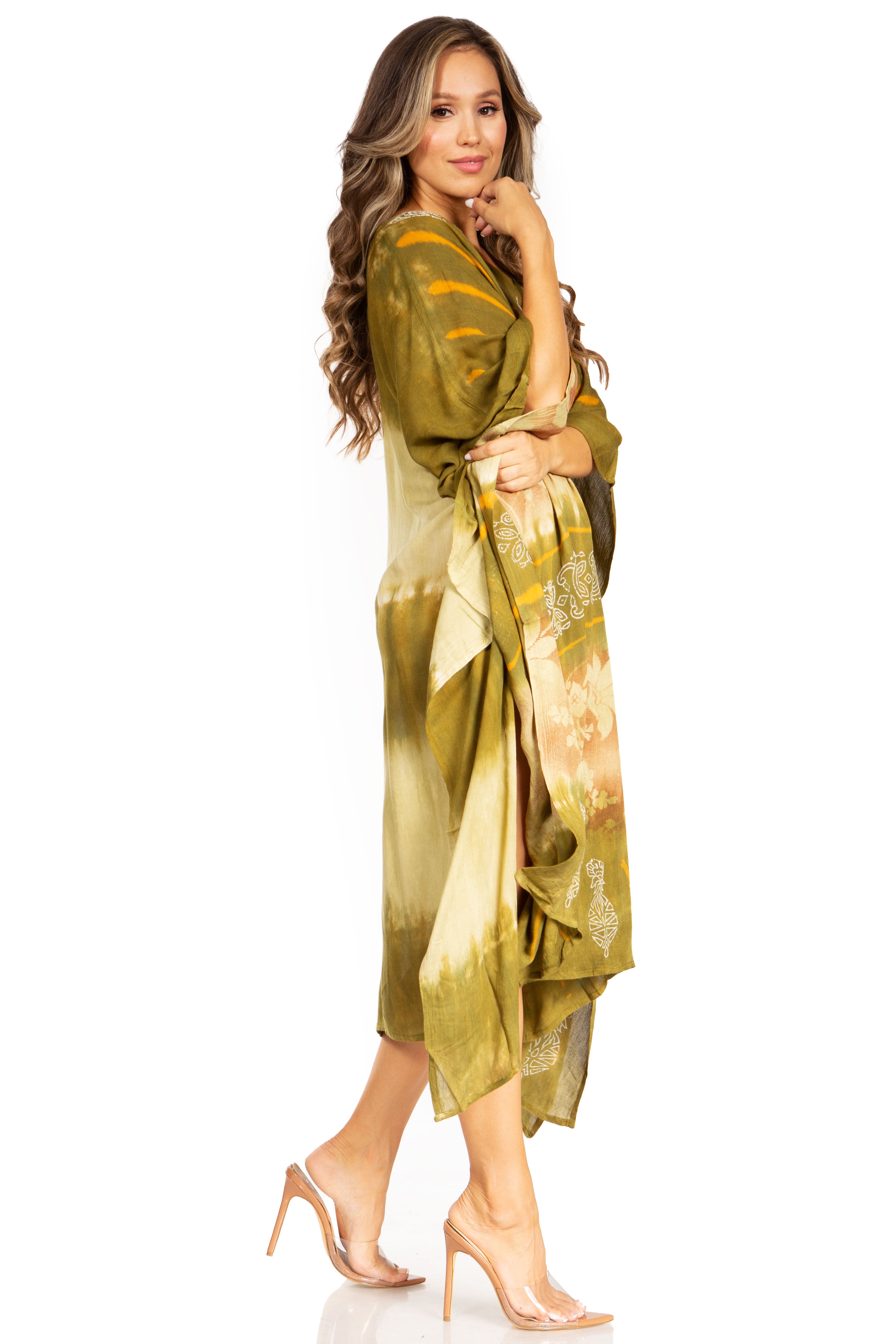 Woman wearing a green and gold dress with a floral pattern on a white background