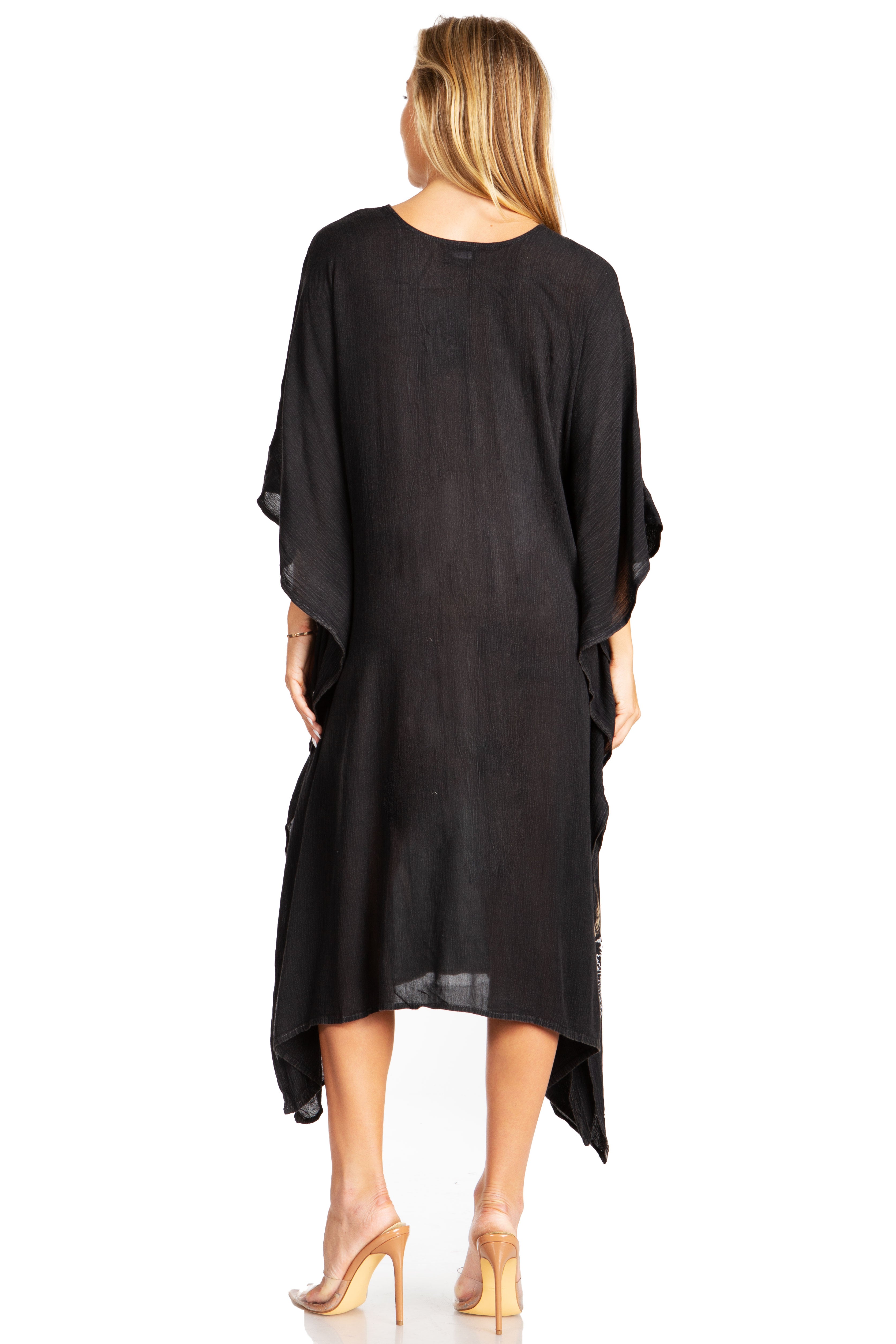 Woman wearing a black dress with sheer sleeves on a white background