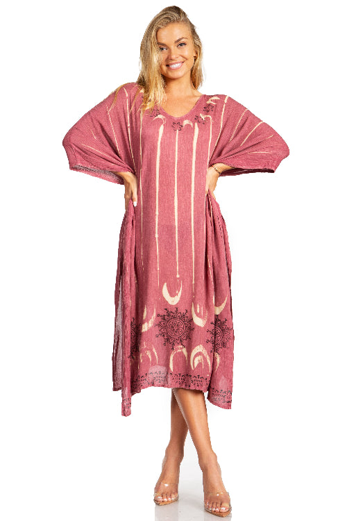 Woman wearing a pink dress with white patterns on a white background