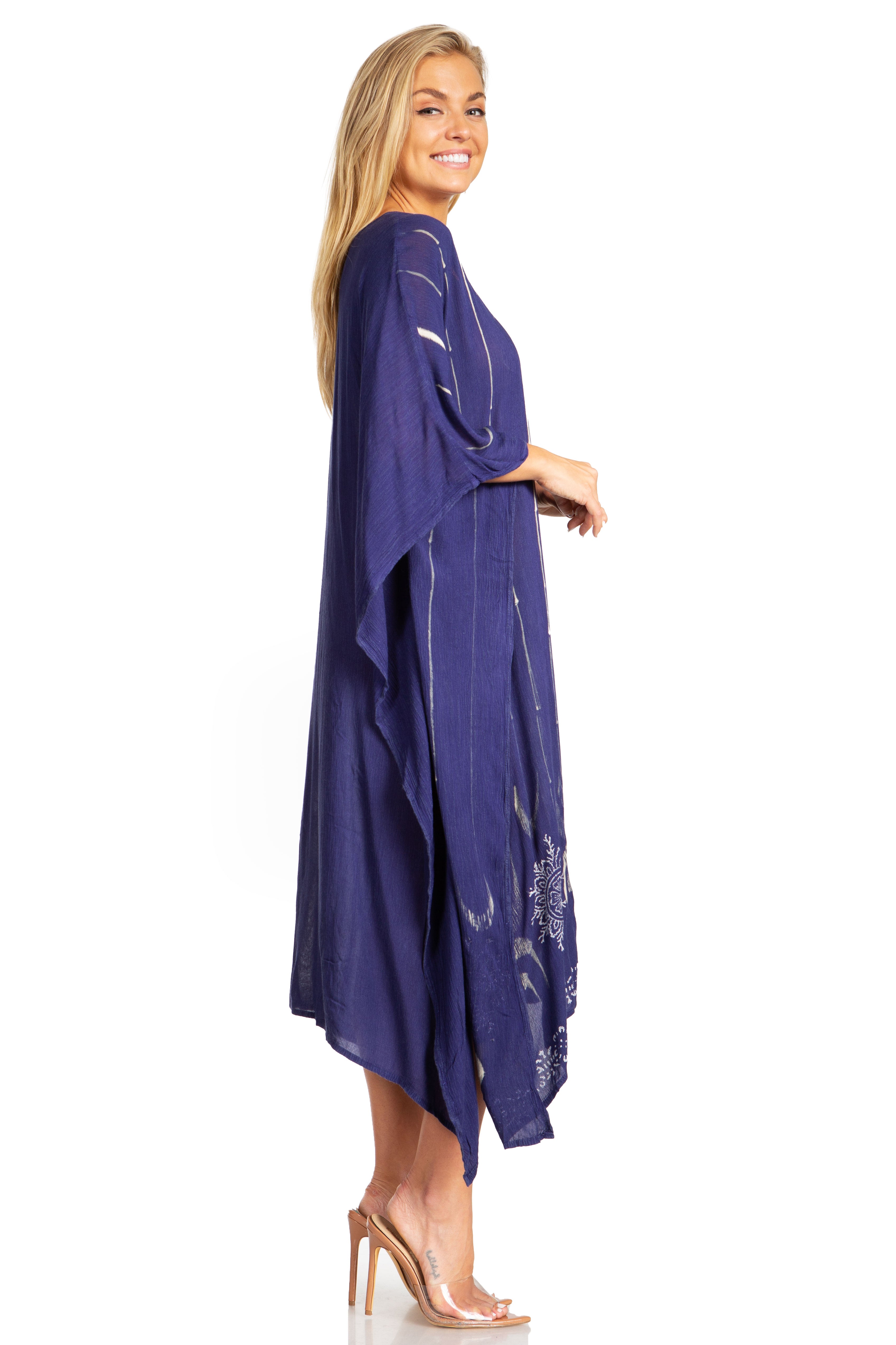 Woman wearing a long purple dress with floral embroidery on a white background