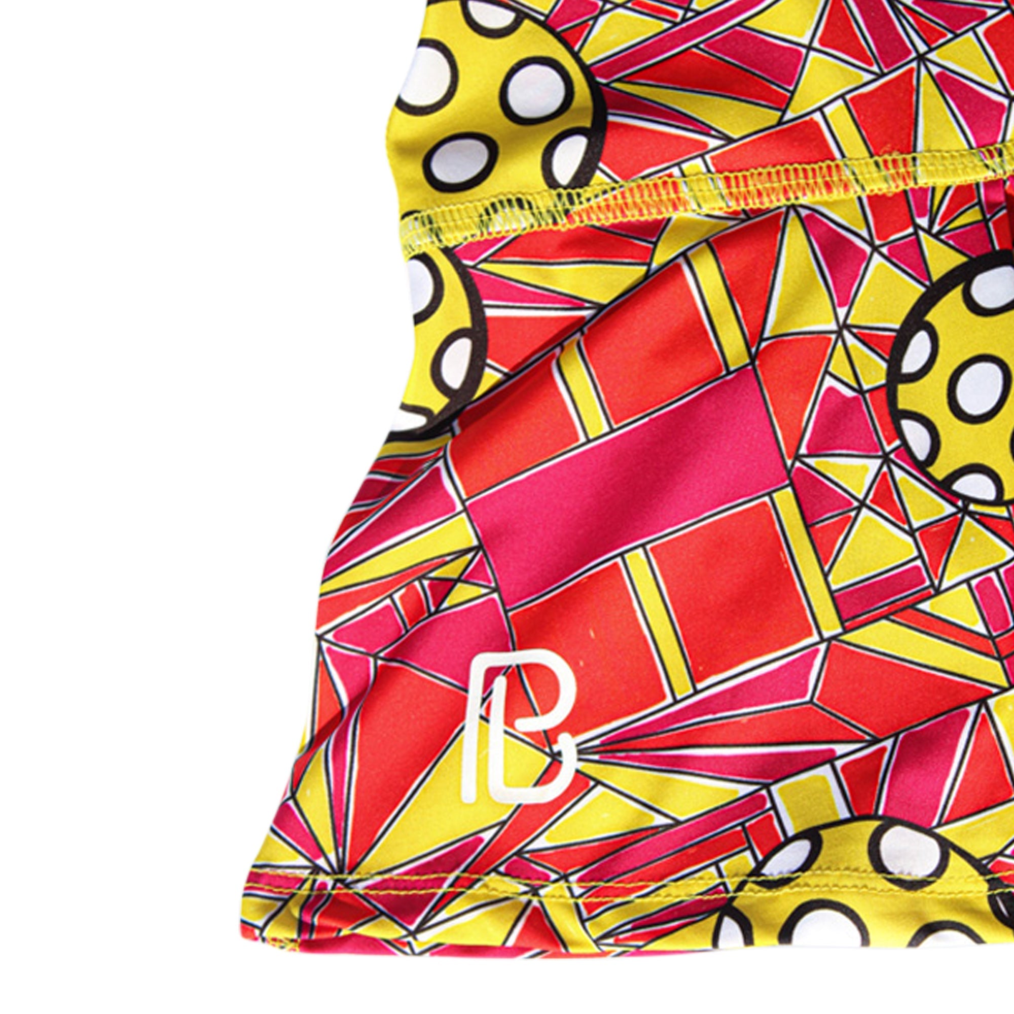 Colorful geometric patterned fabric with polka dot accents on a white background