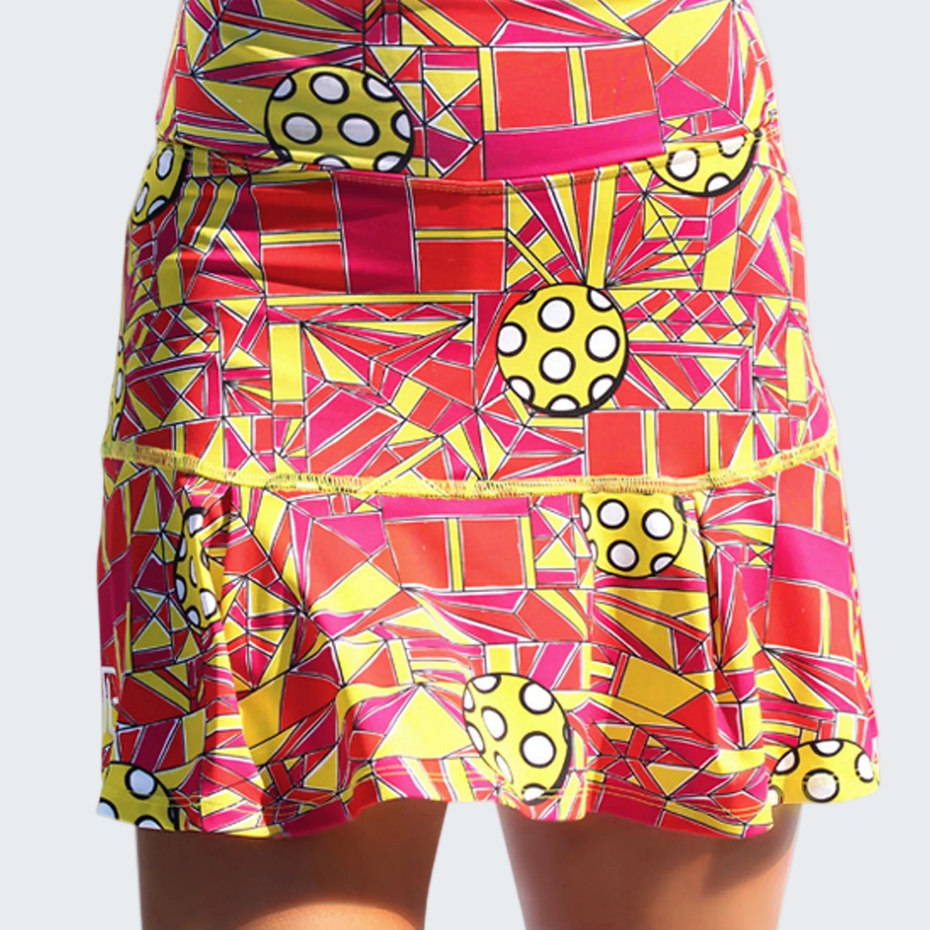 Colorful geometric patterned skirt with polka dot accents on a white background