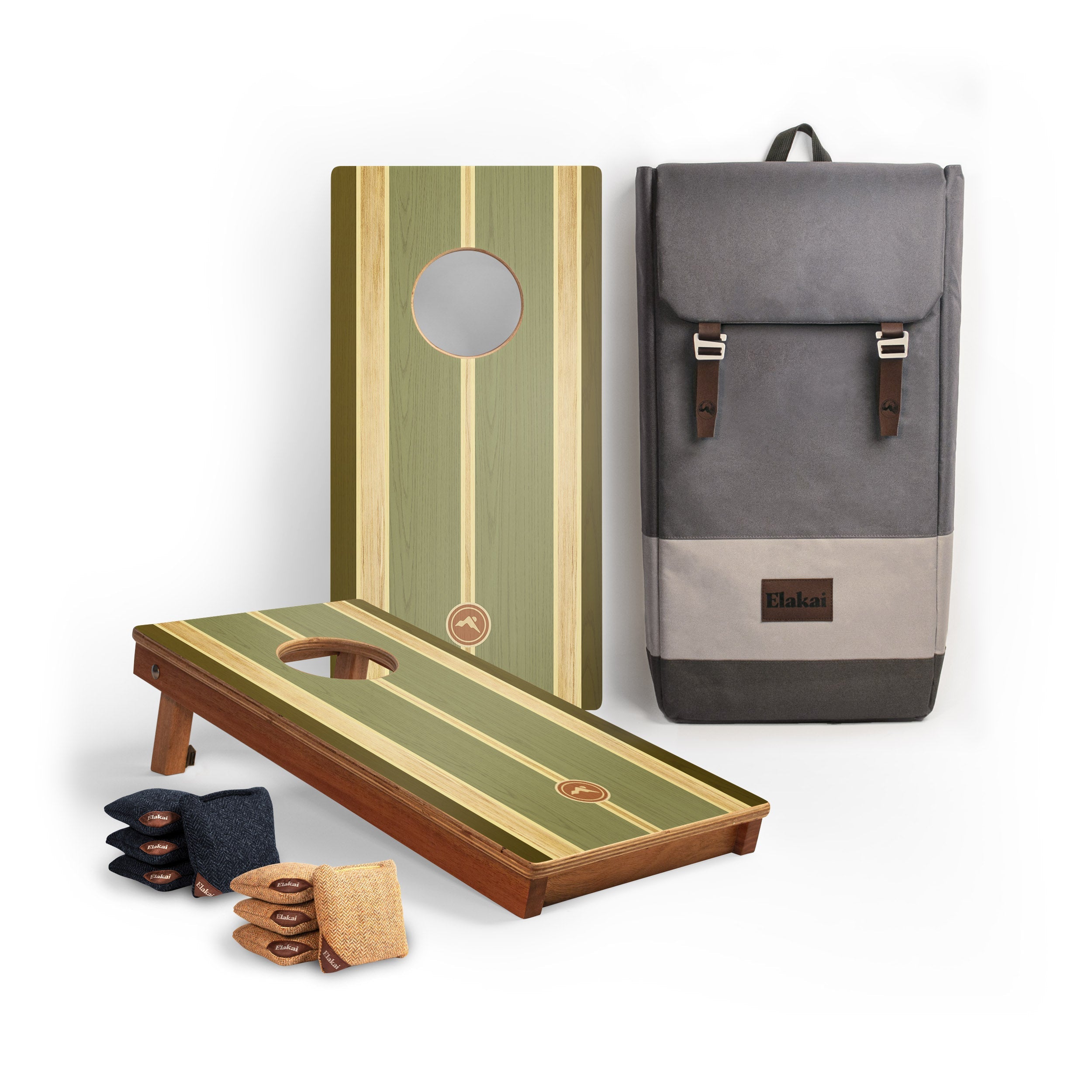 A cornhole set displayed on a white background, including two wooden boards with green and beige stripes, a gray backpack-style carrying case with brown leather straps, bean bags, and cornhole bags.