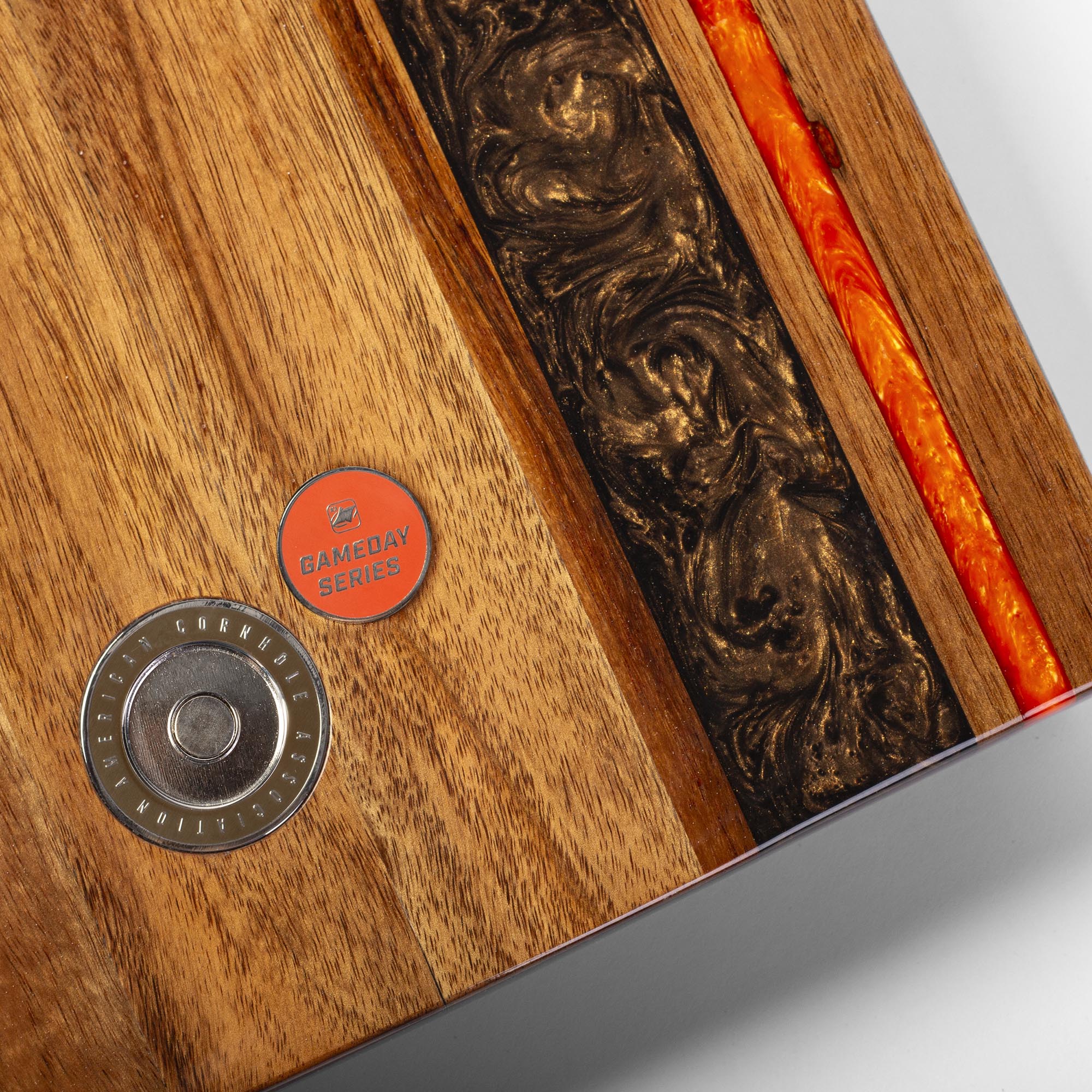 Wooden product with a metallic button and red circular label on a gray background