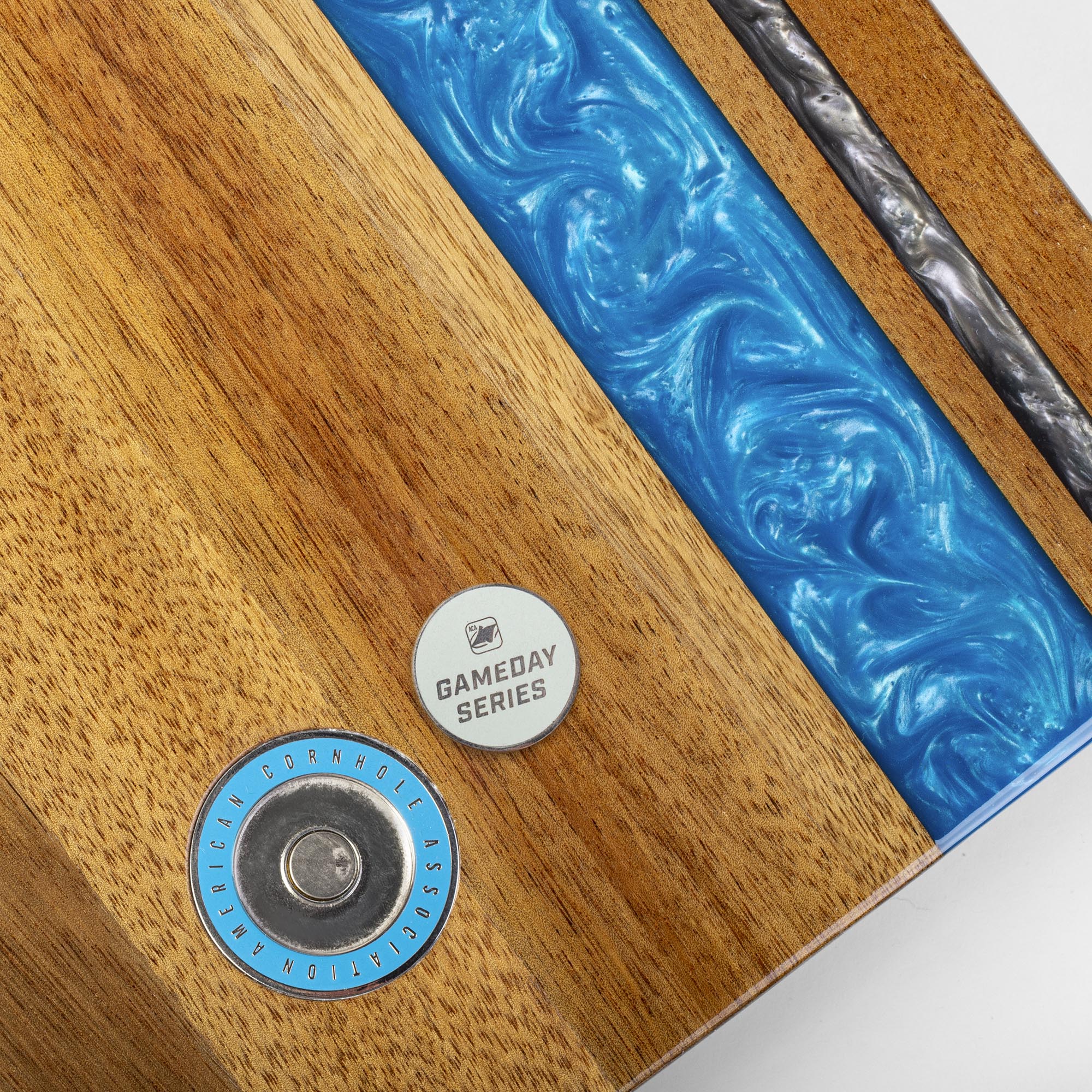 Close-up of a product with 'Gameday Series' label on a wooden and blue resin surface.