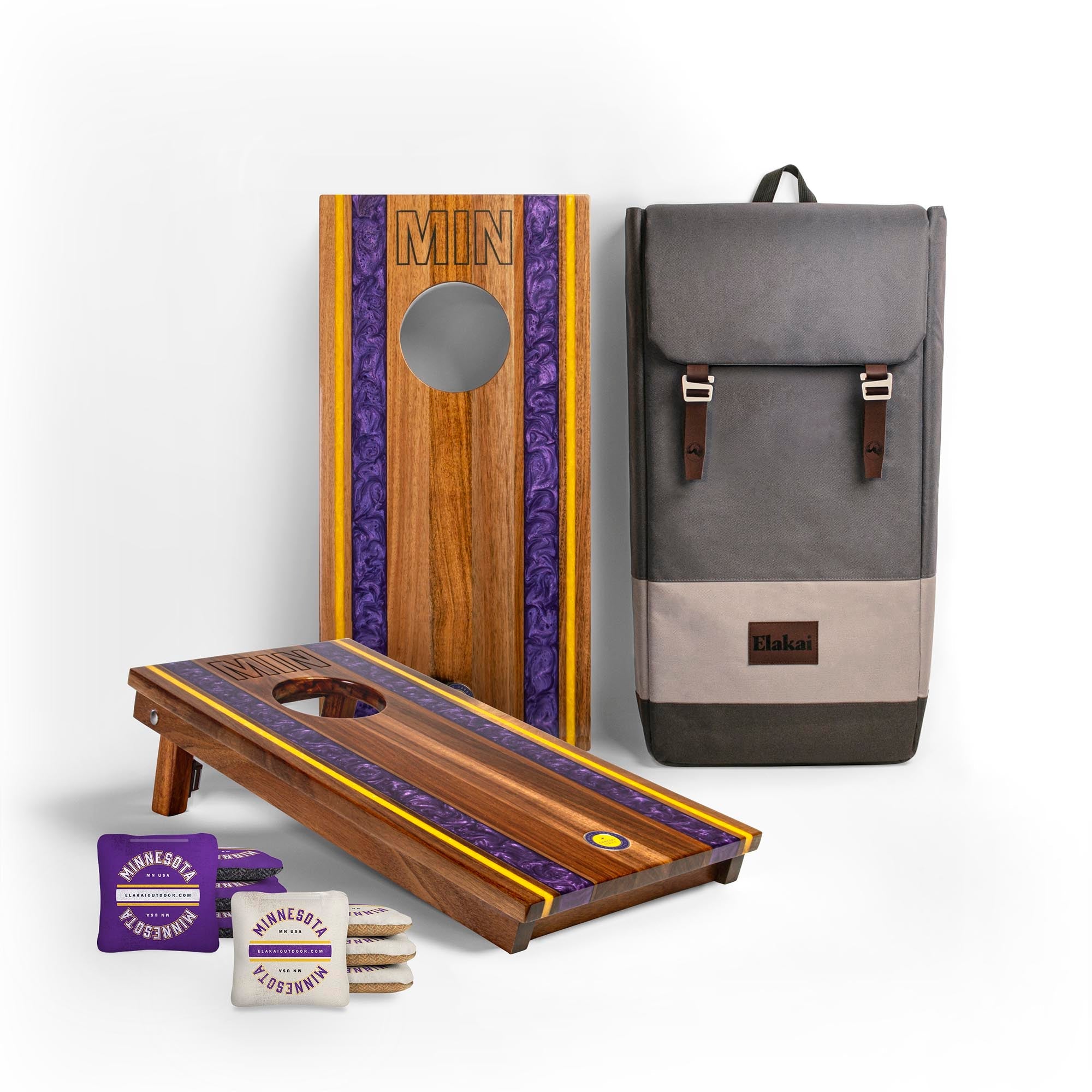 Cornhole board, backpack, and bags on a white background