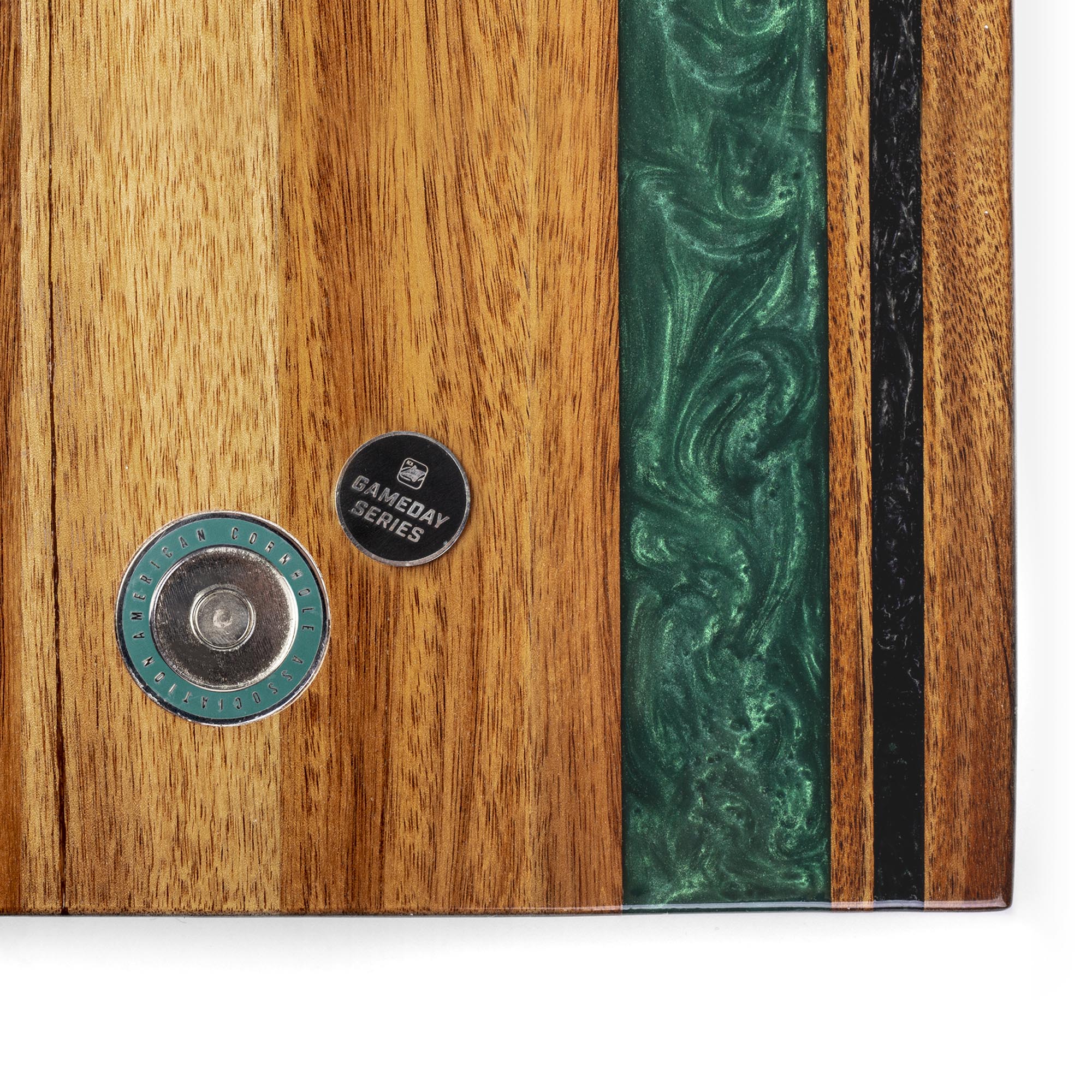 Wooden surface with green inlay and two circular metal components.