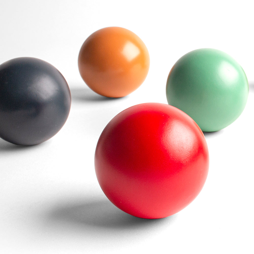 Four colorful balls (black, orange, red, green) on a white background
