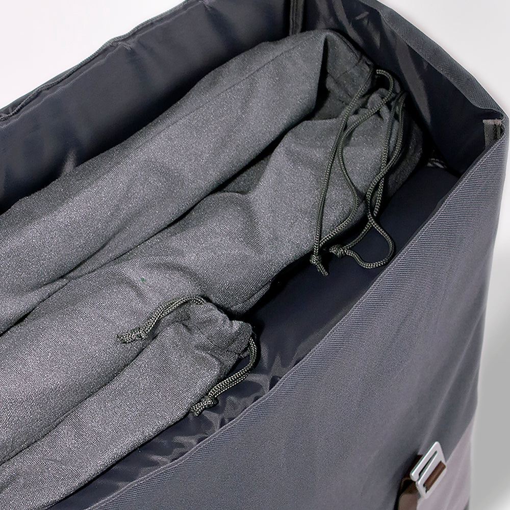 Gray garment bag with folded gray clothing inside on a white background