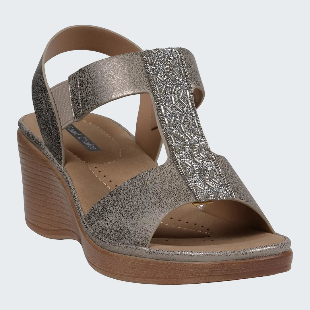 Silver wedge sandal with decorative strap on a white background
