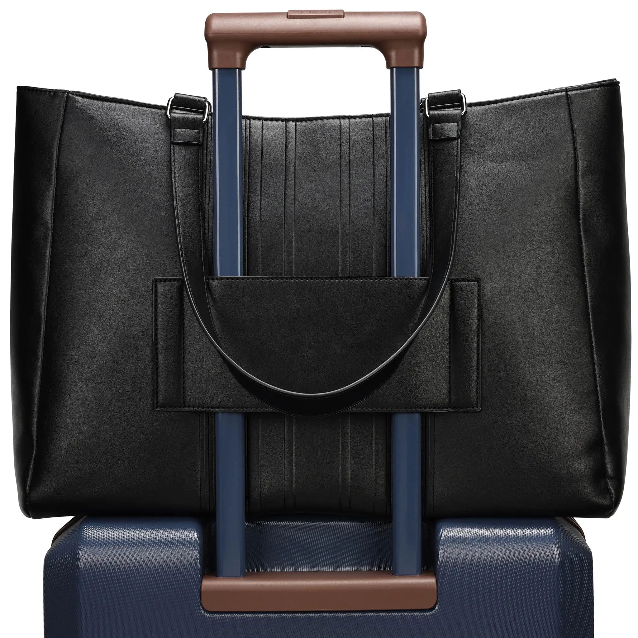 Black leather handbag with brown handle on top of a blue suitcase with brown handle