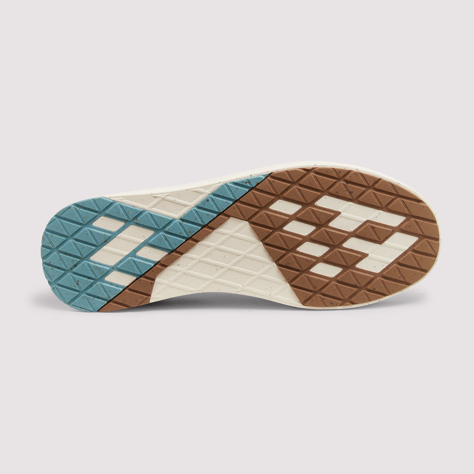 A close-up of a shoe sole showing a geometric tread pattern in brown, cream, and teal blue on a light gray background.