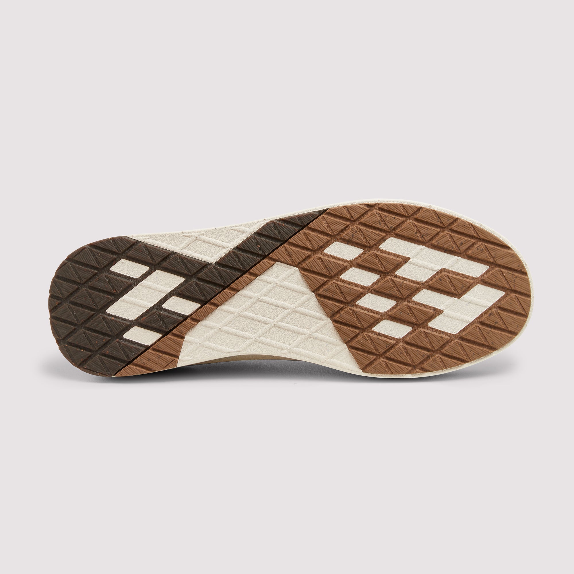 The outsole of a sneaker shown from a top-down view, featuring a geometric pattern in brown, dark brown, and off-white rubber on a light gray background.