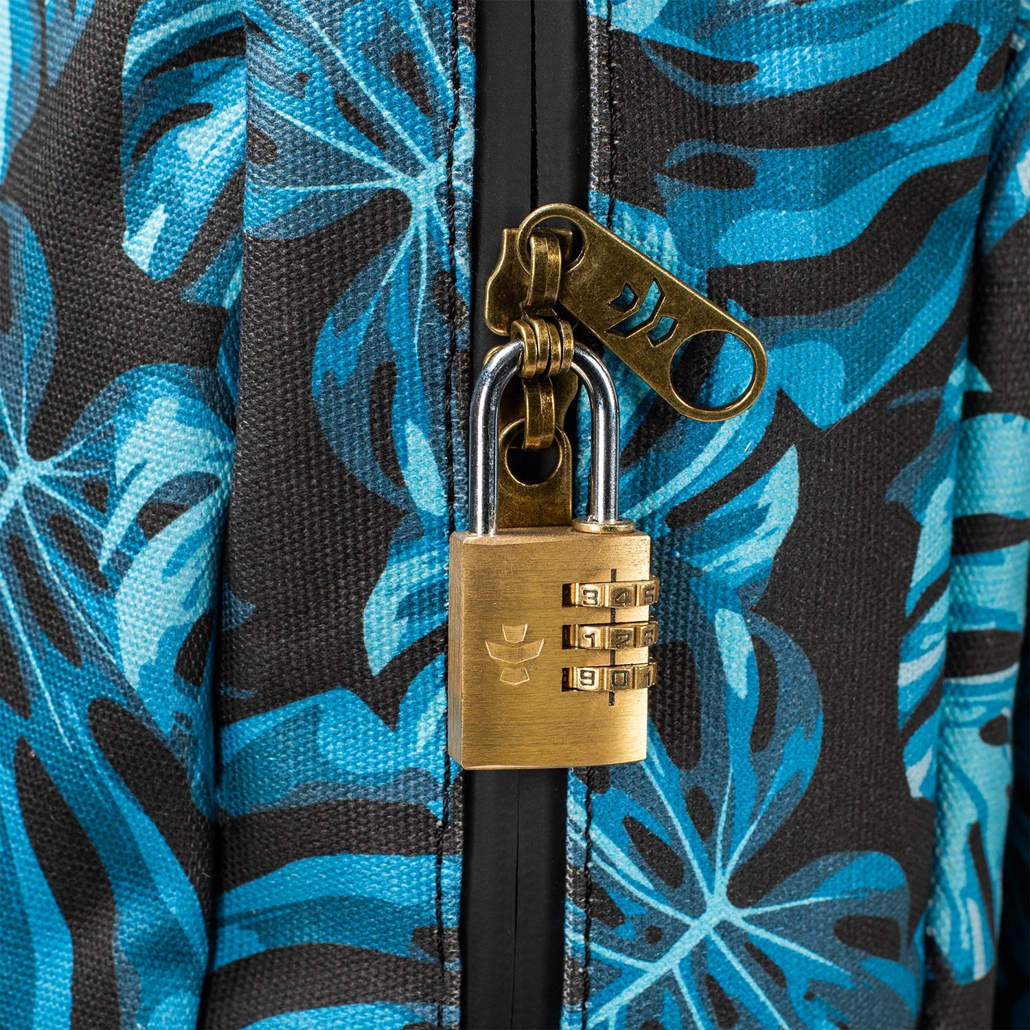 Brass combination lock on a blue and black floral-patterned bag