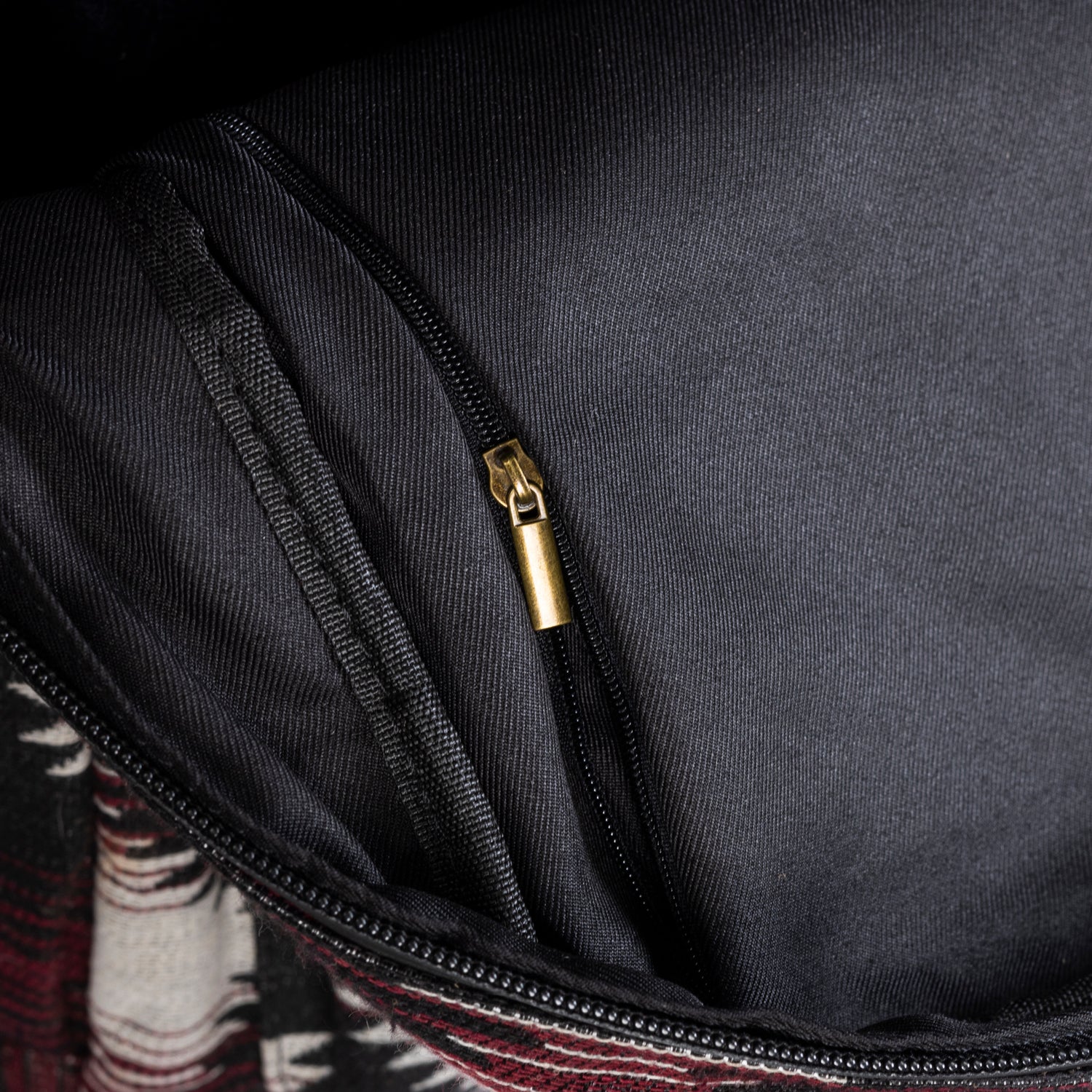 Close-up of a black bag with a gold zipper