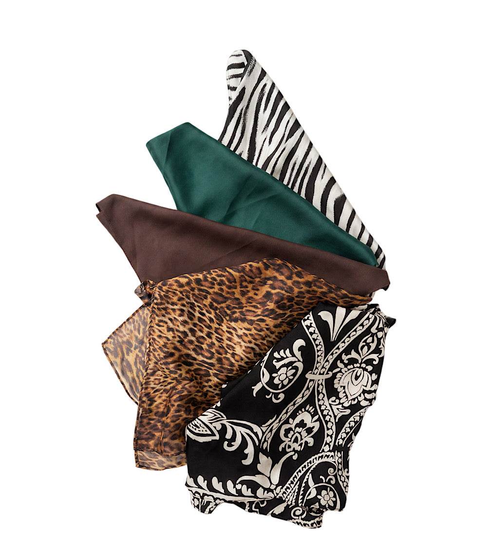 A stack of four patterned fabric scarves or bandanas on a plain white background, showing different designs: zebra print, solid dark green, leopard print, and black and white paisley.