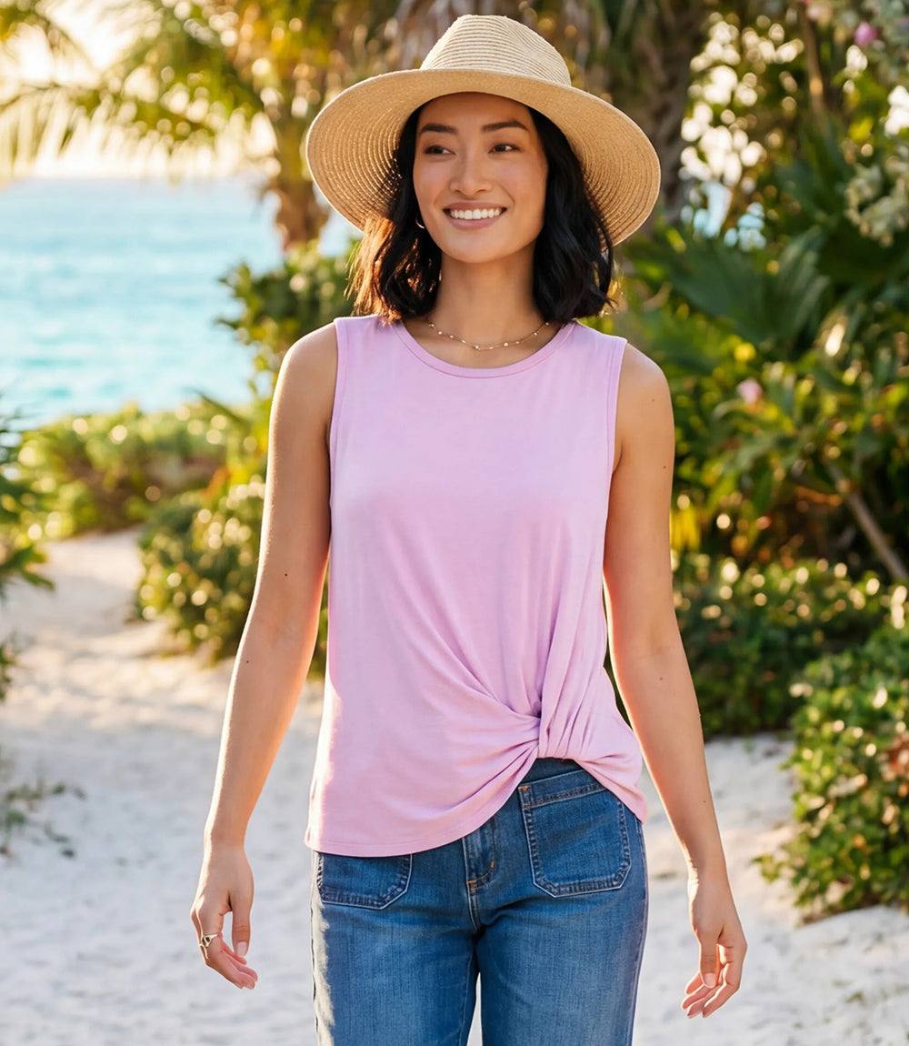 Woman wearing a pink sleeveless top and straw hat on a beach