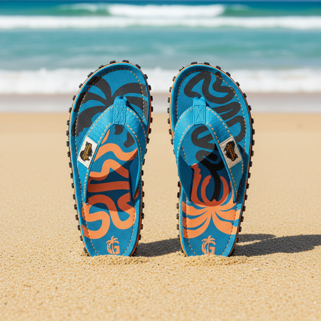 Blue flip-flops with orange and black designs on a white background